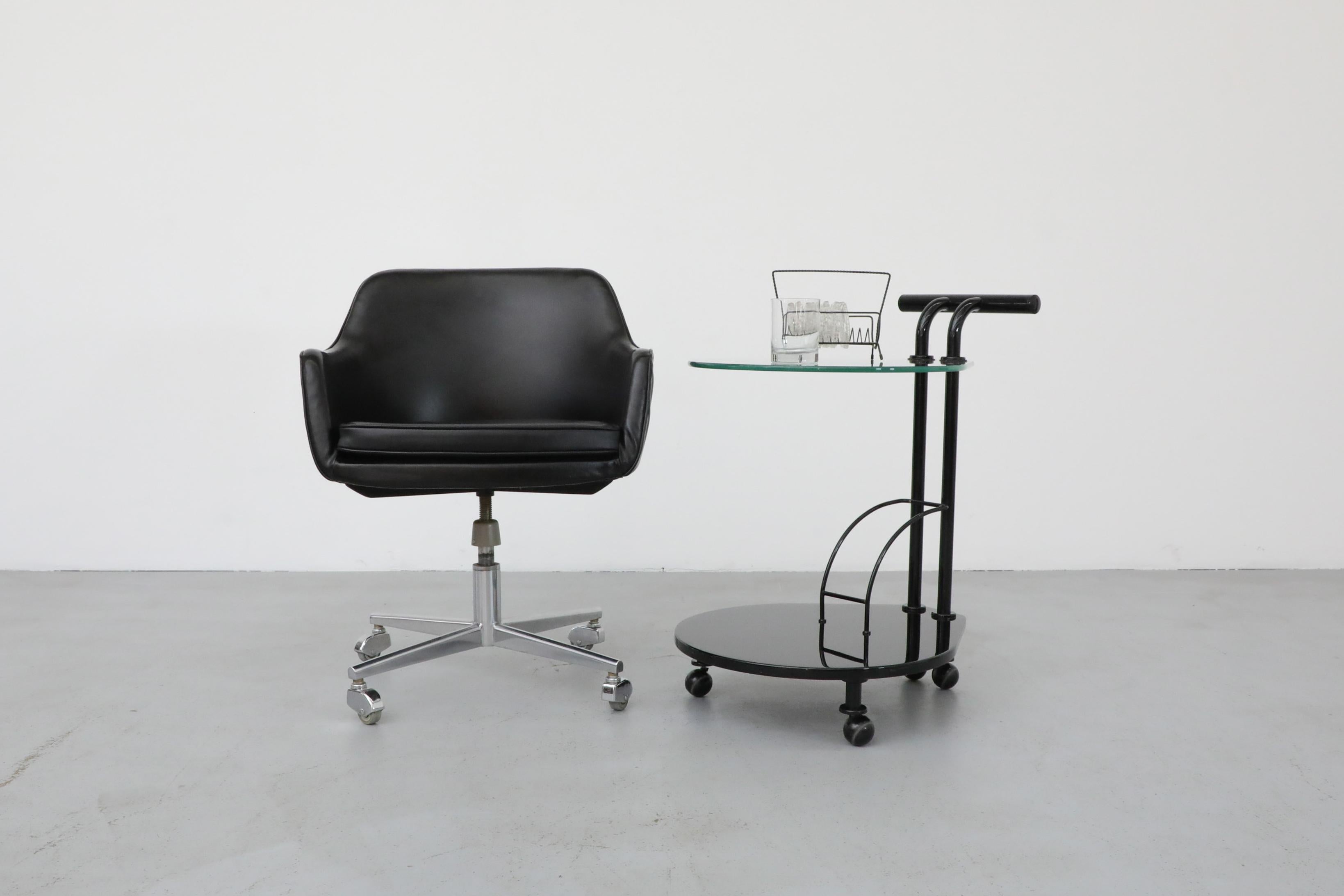 Vintage black faux leather rolling office chair with chrome base and wheels. The seat cushion is new vintage vinyl. Height adjustable. Just spin baby, spin! In original condition with visible wear consistent with its age and use. Shown with Memphis
