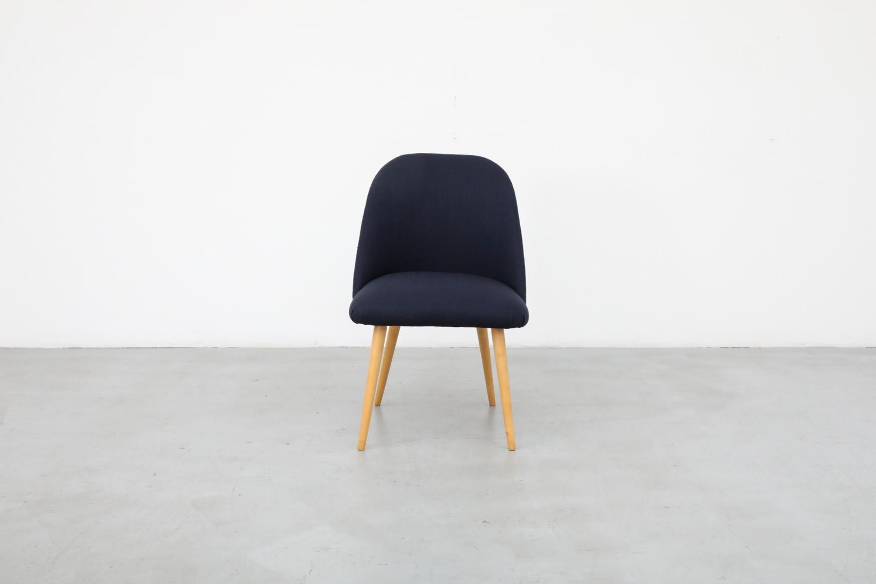 Mid-Century, Eero Saarinen style accent or cocktail chair with natural birch tapered legs and newer navy fabric . In otherwise original condition with some visible wear consistent with age and use. Many similar chairs available in varying sizes,