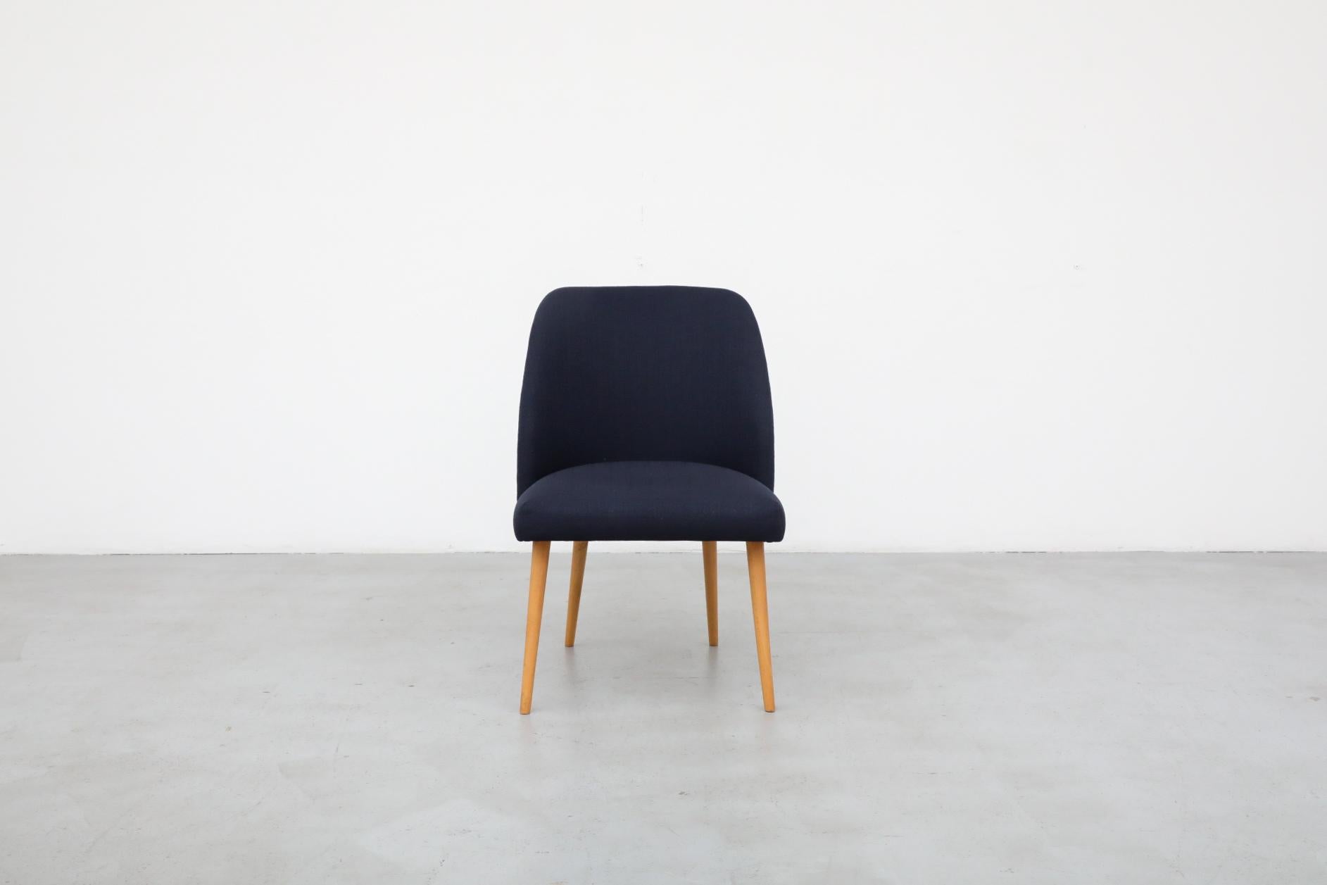 Single, Saarinen style cocktail chair in newer navy fabric with natural birch tapered legs. Extra comfort provided by a wider profile with a squared top. Shown with stunning Mason Charles floor lamp (LU922427580502). The frame is in original