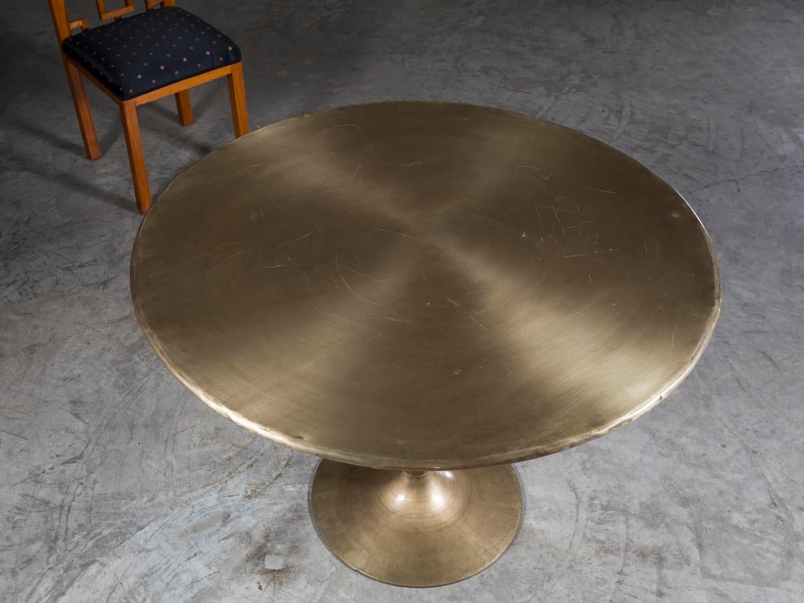 A striking round brass Saarinen style dining table from Holland. The elegant restraint exercised by Saarinen in the creation of his famous Tulip table is evident here withe circular base supporting a vertical stem with the round top of the table all
