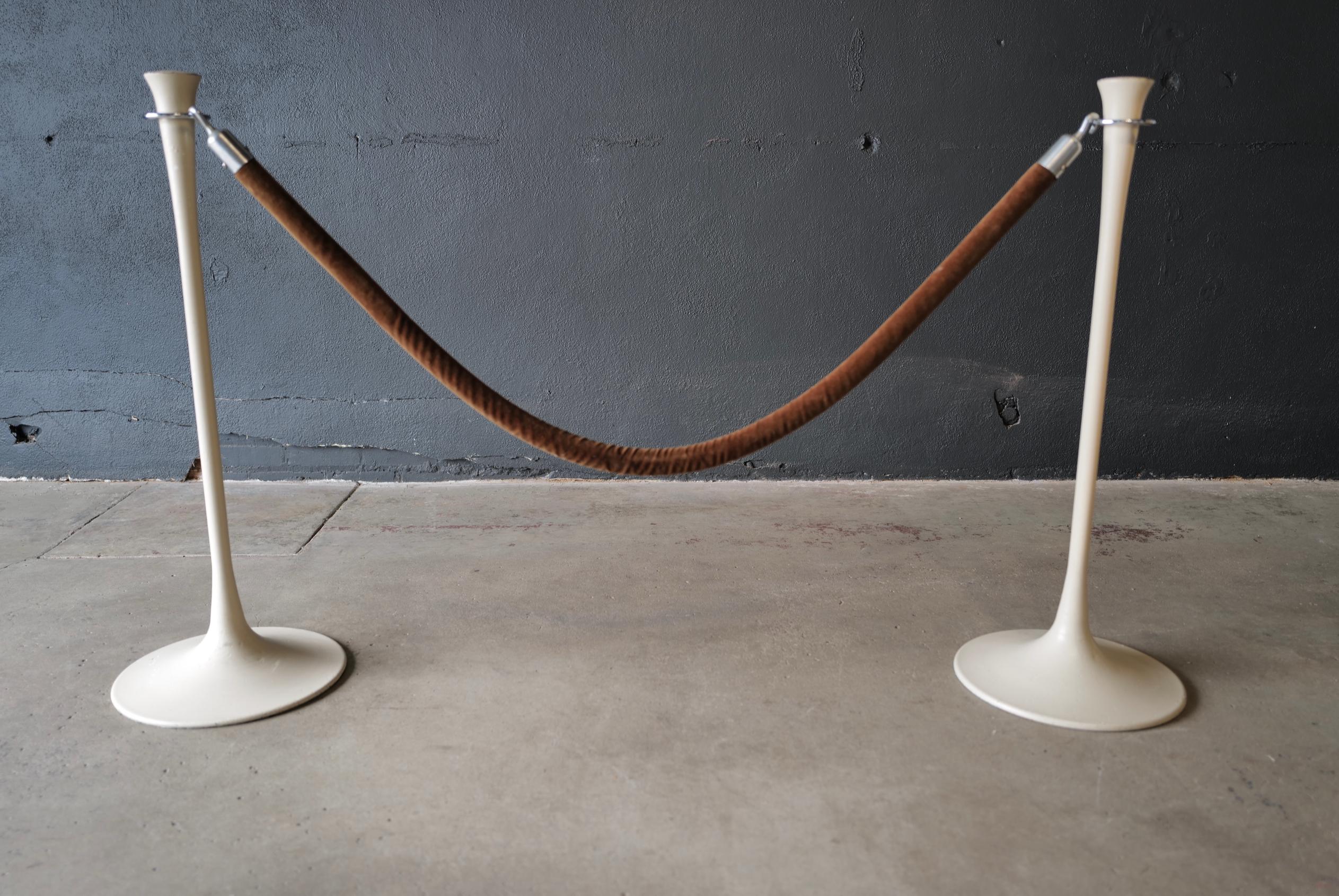 These mid-century Saarinen style stanchions with brown velvet rope exude elegance and sophistication. The stanchions feature the iconic tulip-shaped bases, inspired by the designs of renowned architect Eero Saarinen. The bases are crafted from