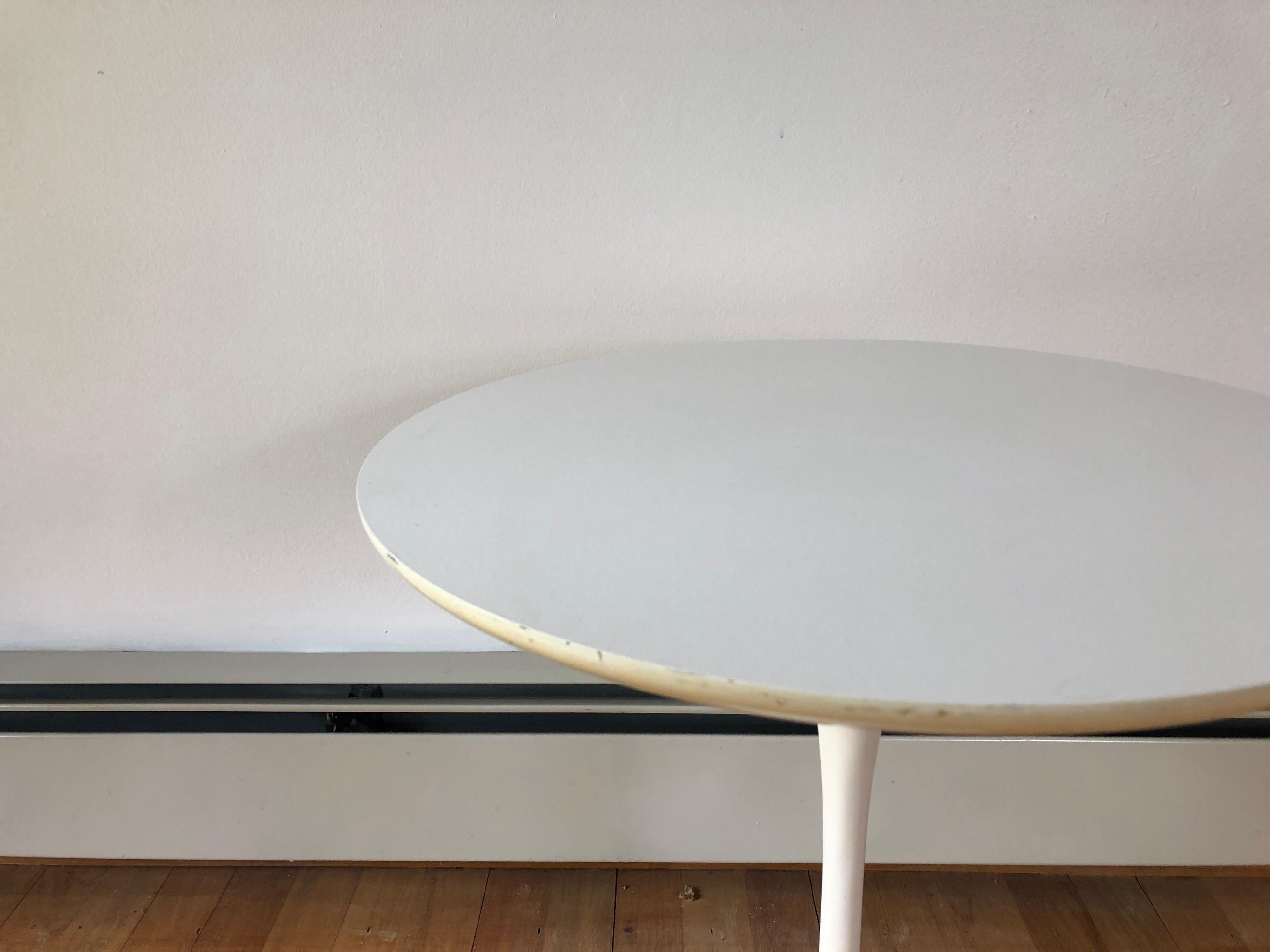 A Saarinen style tulip side table with metal base and laminate top.
