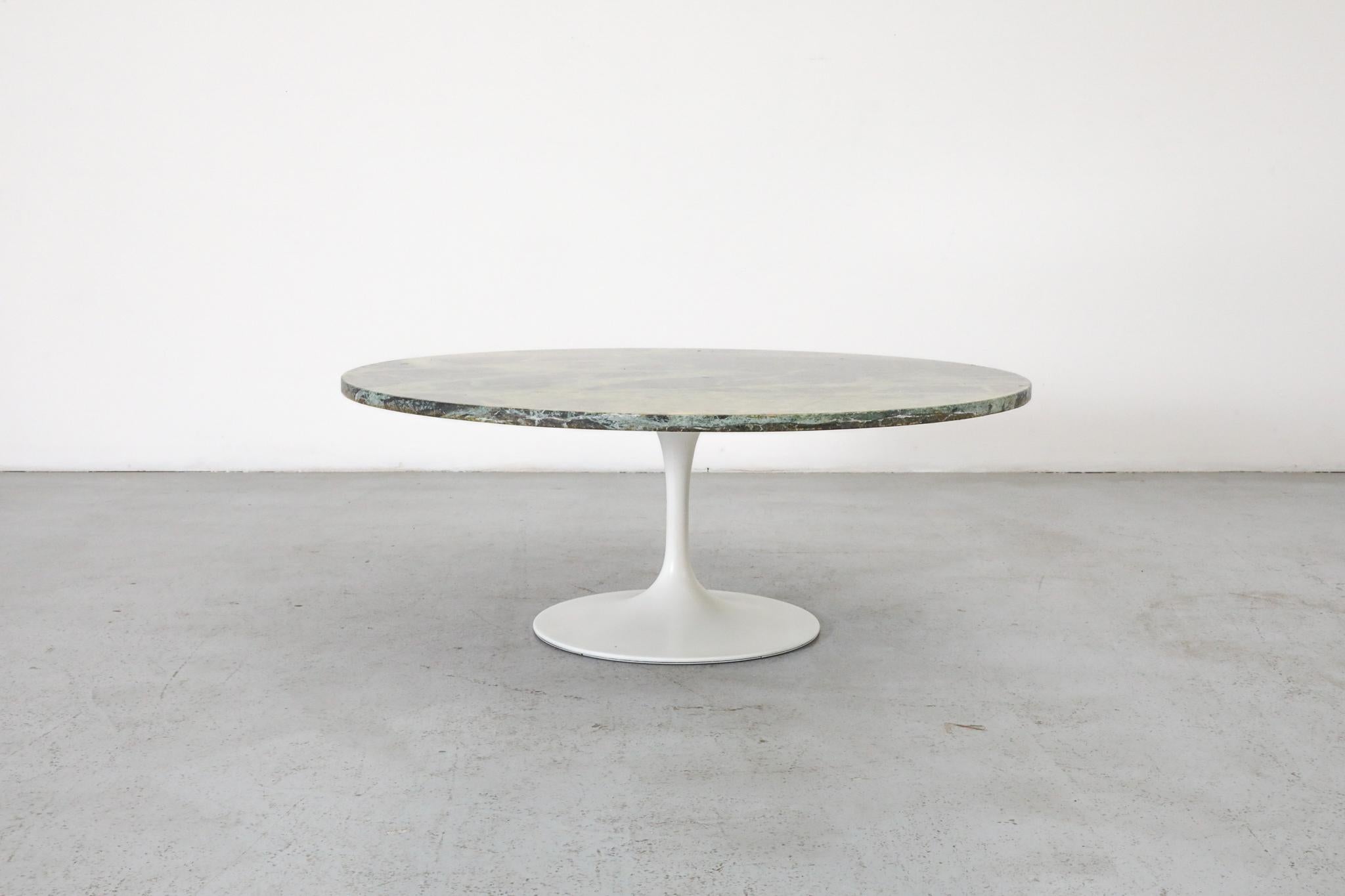 Une table ronde à café ou d'appoint du milieu du siècle dans le style emblématique d'Eero Saarinen. Cette pièce présente un plateau en marbre vert Verde Alpi sur une base tulipe classique en métal émaillé blanc.

Le marbre Verde Alpi se caractérise