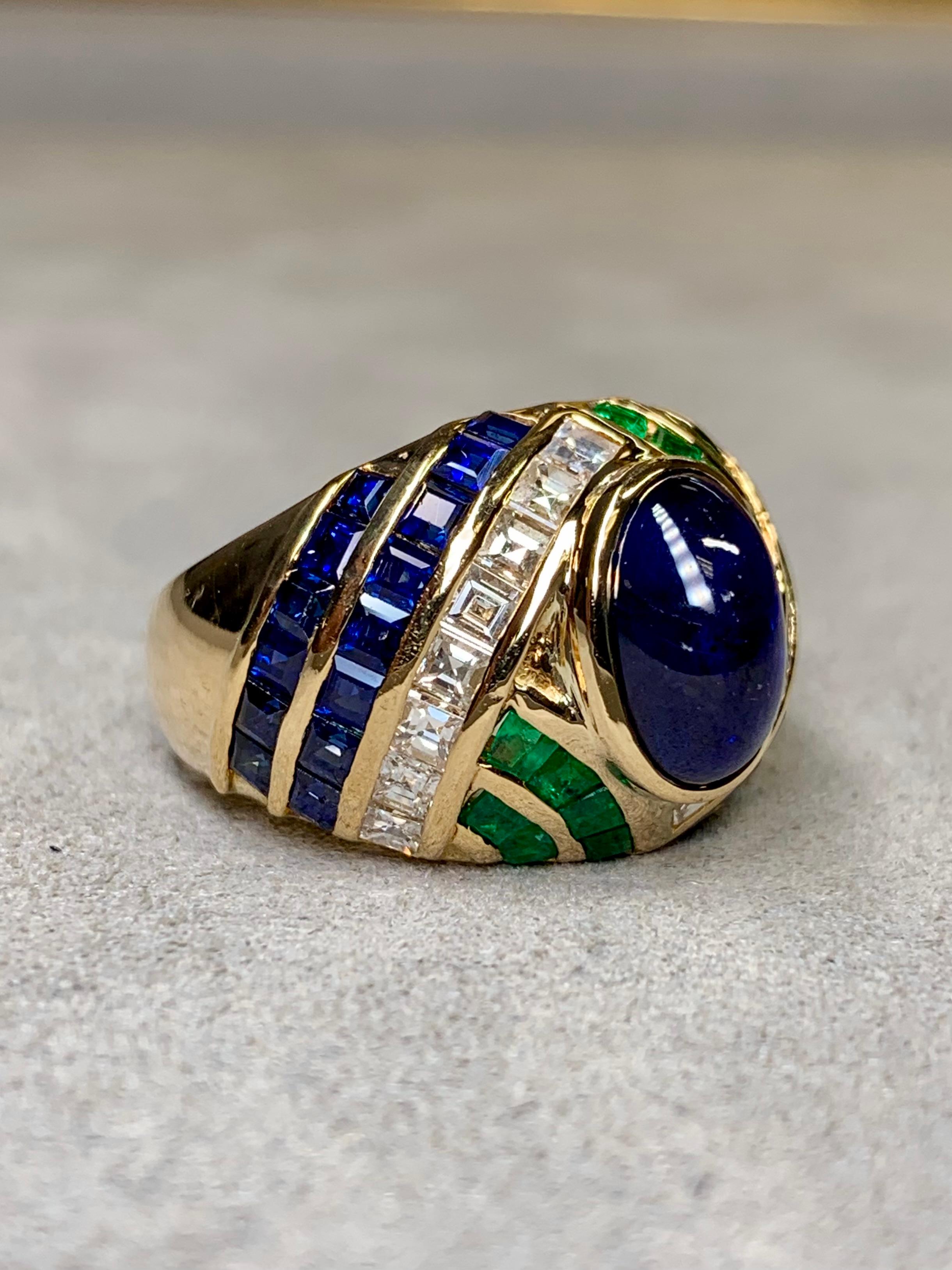 A vintage cocktail ring circa the mid 1990’s by Italian maker, Sabbadini. It is done in 18K yellow gold and centered by an approximately 3.90ct (by formula) natural, high-topped cabochon sapphire which is flanked by 1.20ctw in square cut emeralds,