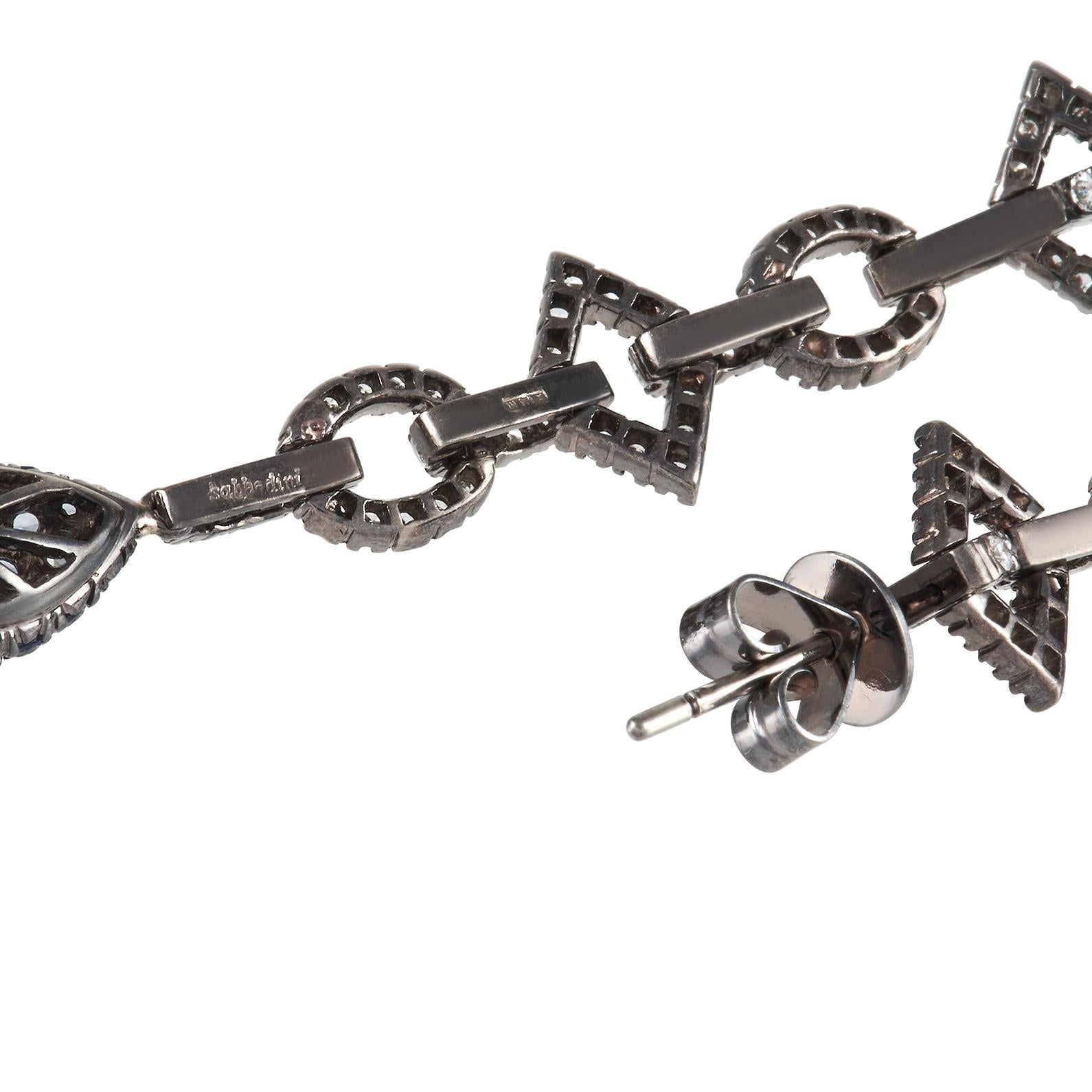 A stunning 18K White Gold setting makes these Sabbadini earrings impossible to ignore. Each one of these luxurious earrings features a dramatic, geometric design that measures 2.25” long by .25” wide. Diamonds totaling 1.50 carats make them sparkle