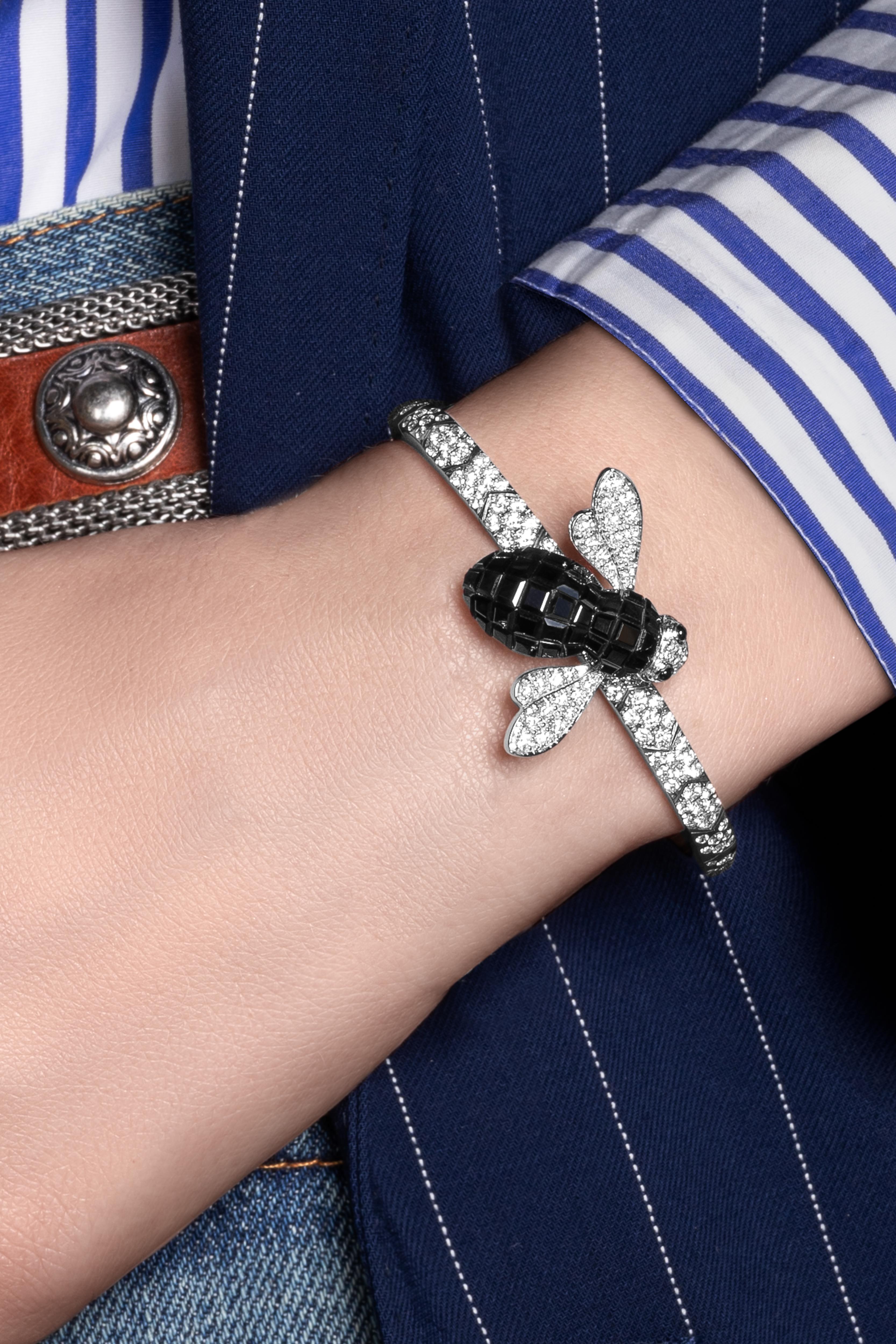 Titanium diamond bangle, white gold and diamond and invisible setting black sapphires bee motif.
The titanium bracelet has a spring inside which makes it flexible and adapts to every wrist size.
The Bee Brooch, originally designed by Alberto