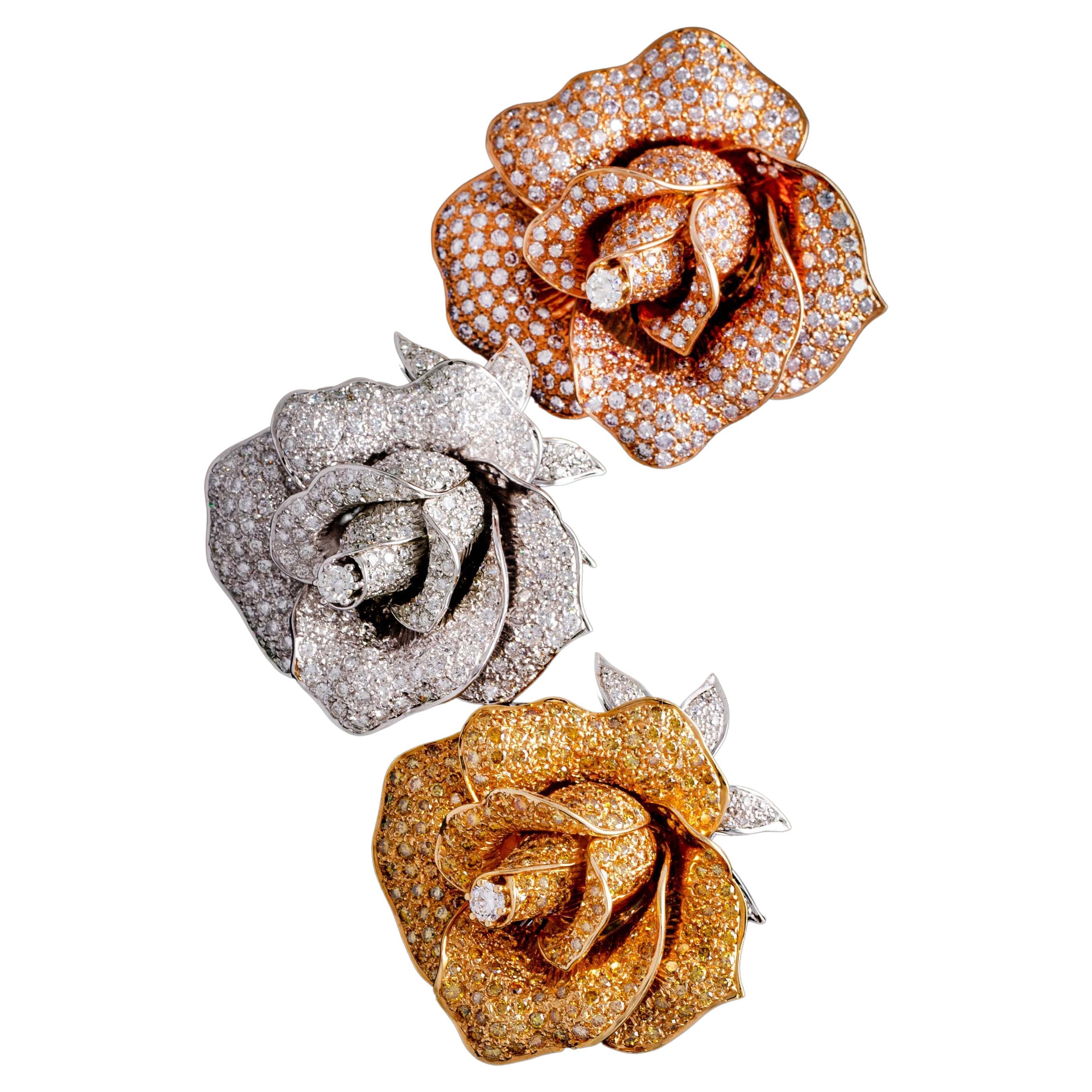 Three Diamond and 18K Gold brooches representing roses.

Dimensions: 
Pink: approximately 5.50 x 5.00 centimeters.
Yellow: approximately 5.20 x 4.70 centimeters.
White: approximately 5.20 x 4.70 centimeters.

Total weight: 118.71 grams.
(Pink: 40.90