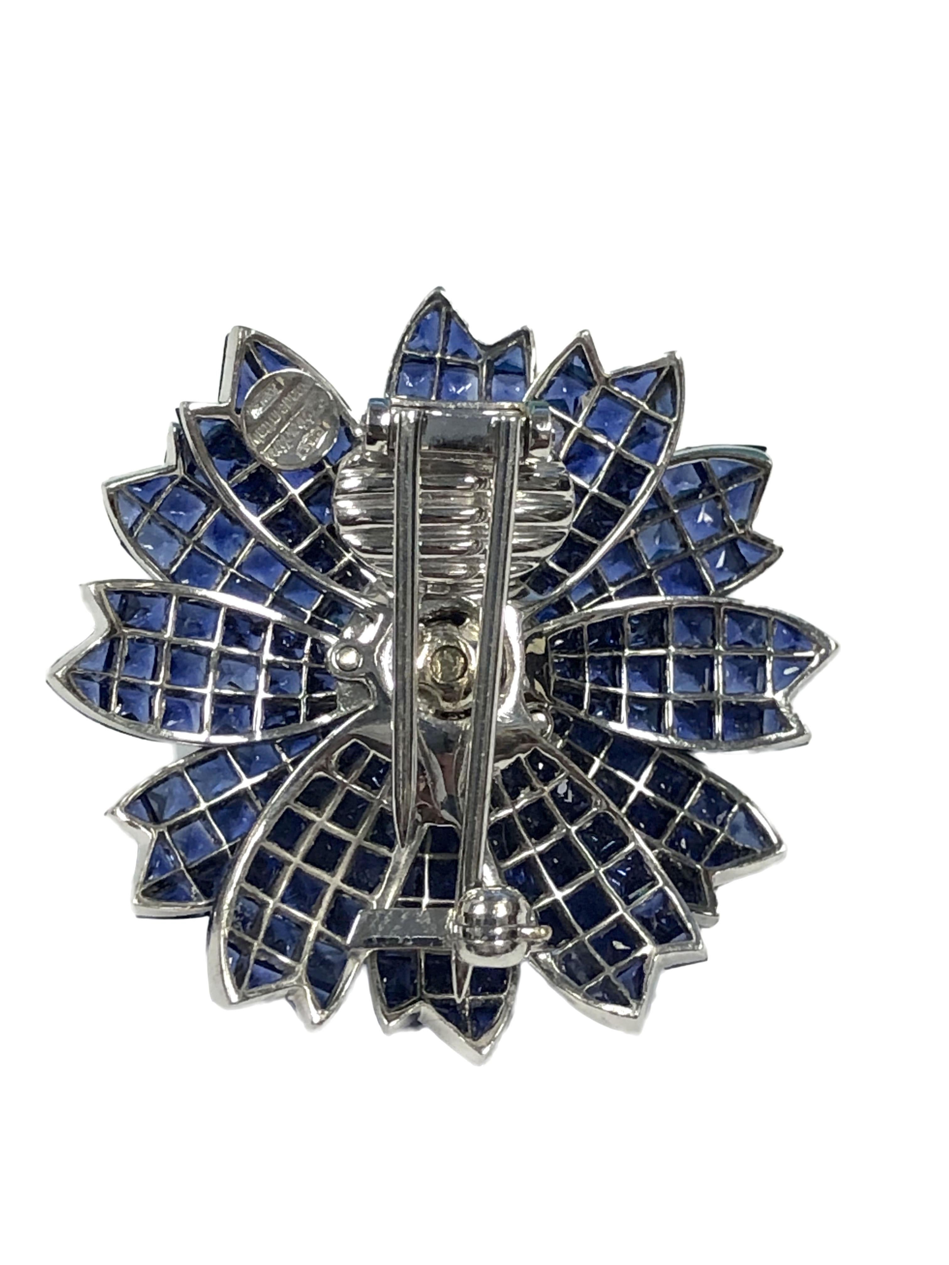 Sabbadini of Italy 18k White Gold Flower form Brooch, measuring 1 3/8 inches in diameter, Invisibly set with very Fine Gem color Sapphires totaling approximately 30 Carats and further set with Round Brilliant cut Diamonds totaling 1.25 Carats. 