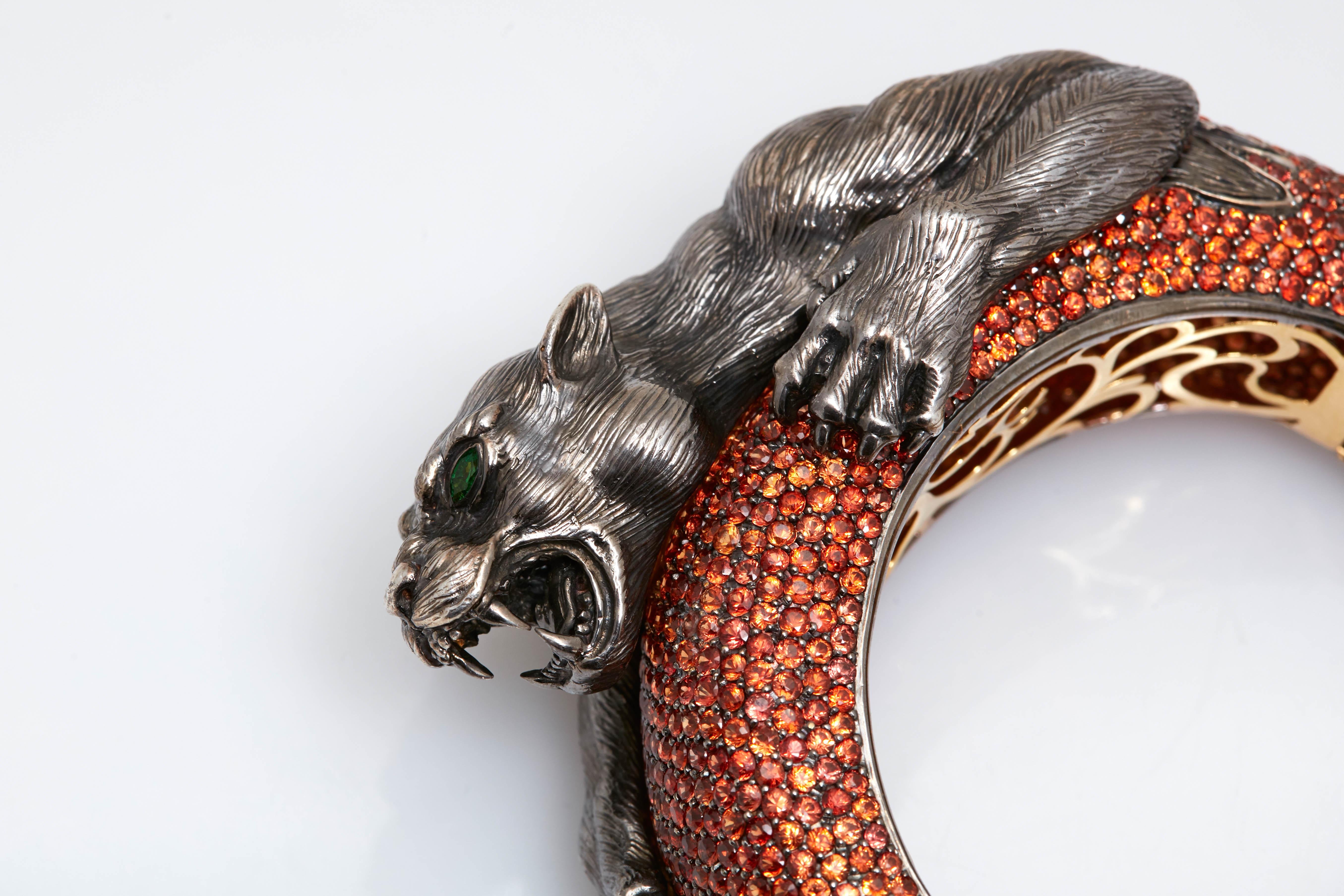 A panther bracelet in 18kt yellow gold and black rhodium with orange sapphires; hand-textured feline beast made of sterling silver with emerald eyes. Signed by Sabbadini, made in Italy, circa 1980s.
