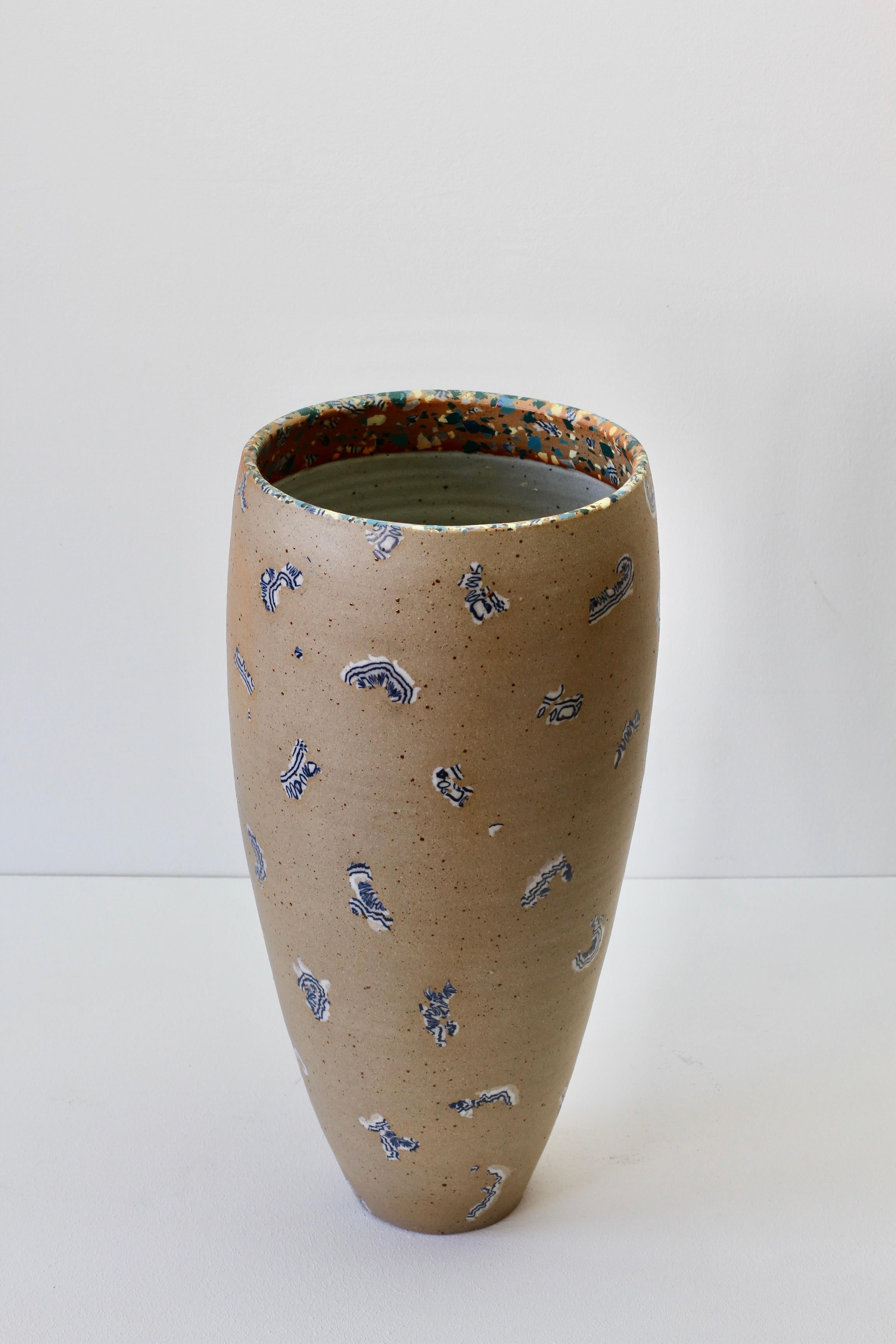 Wonderful unique tall stoneware vase by German artist Sabine Mooshammer, circa 1992. This piece of art Studio Pottery is really rather exquisite with the beautiful blue and white 'mosaic' inclusions throughout the main body of the vase together with