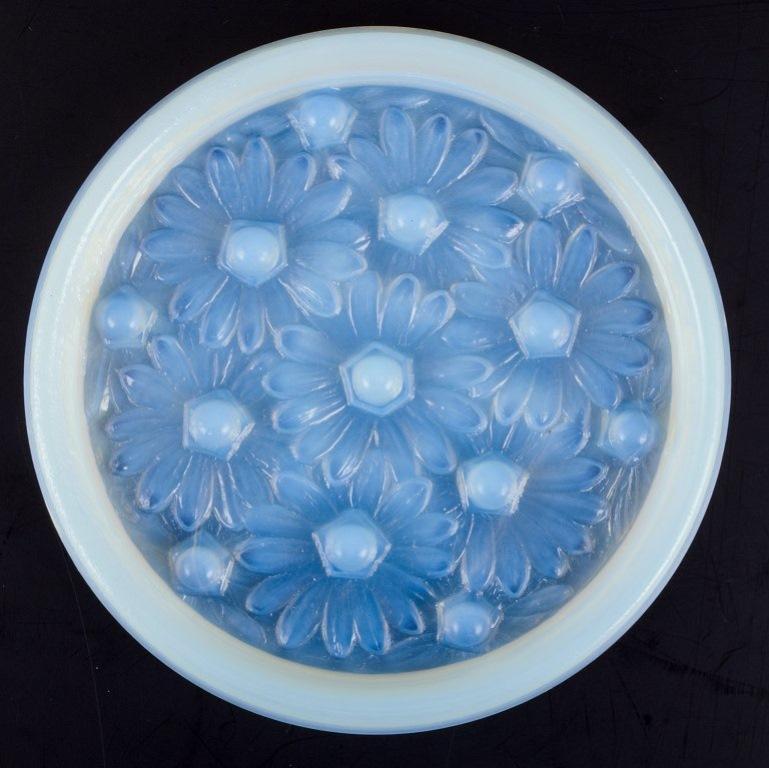 Sabino, France. A dish in art glass with raised flower motifs. 
Art Deco opaline glass with a bluish tint.
Approximately from the 1930s.
In perfect condition.
Dimensions: D 15.5 cm x H 1.5 cm.