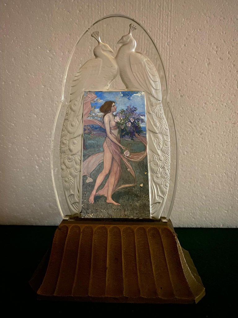 Seltener Sabino-Leuchtrahmen aus Klar- und Milchglas mit der Darstellung zweier sich gegenüberstehender Pfauen auf einem vergoldeten Metallsockel.