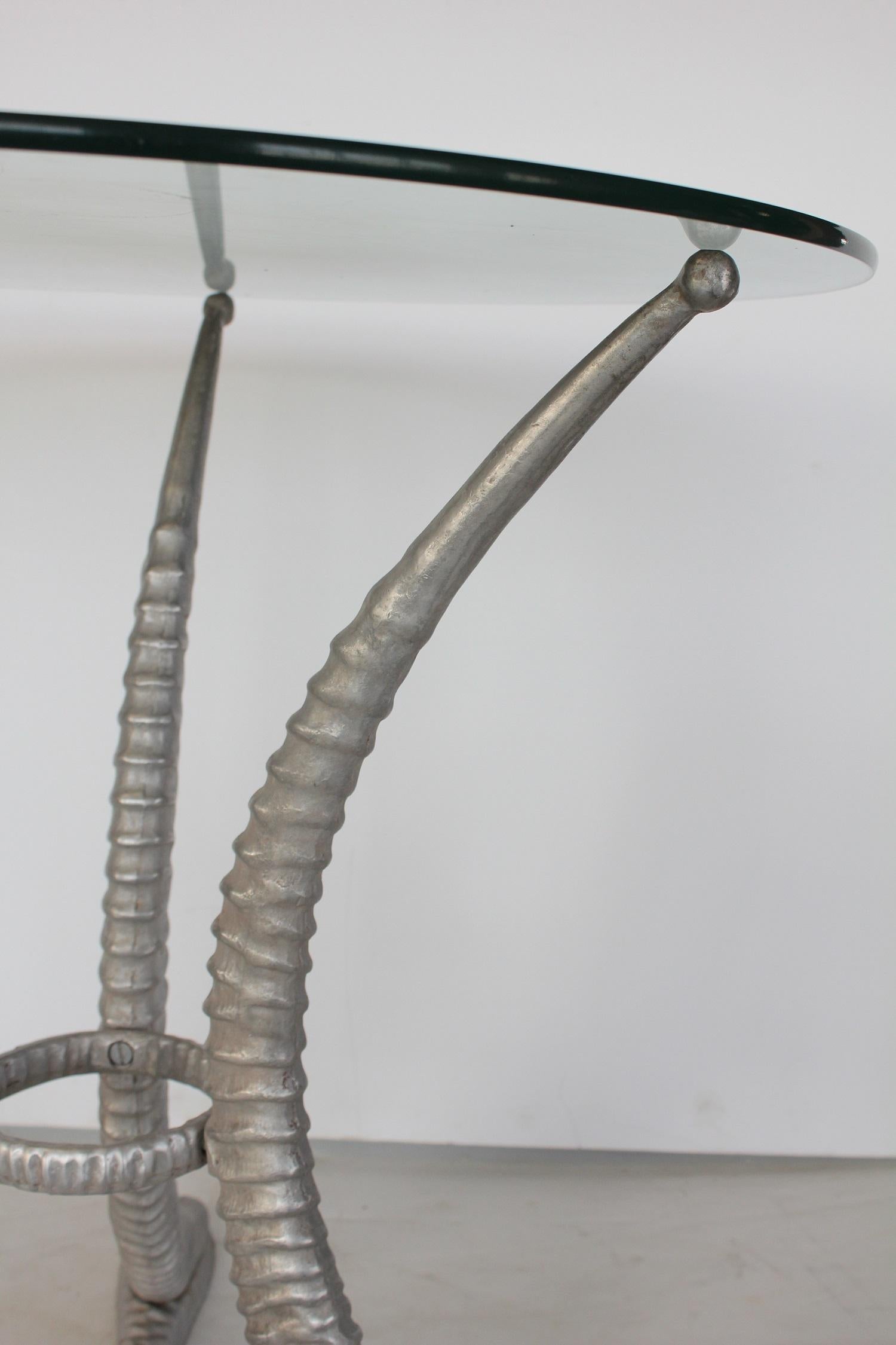 Sable horn cast aluminum center table with glass top. Designed by Arthur Court.