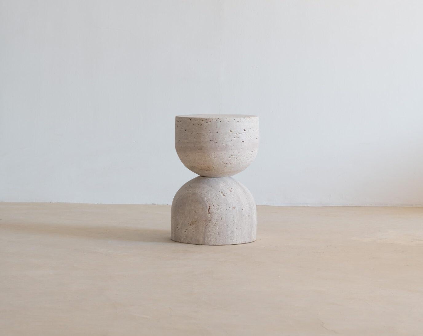 Tavolino a forma di clessidra in travertino Sablia Muted Beige di Beije Avenue
Dimensioni: Ø 31 x H. 46 cm. 
Materiali: Travertino.

Il nostro tavolino Sablia, realizzato in travertino organico, è ideale come tavolino da divano, come piedistallo o