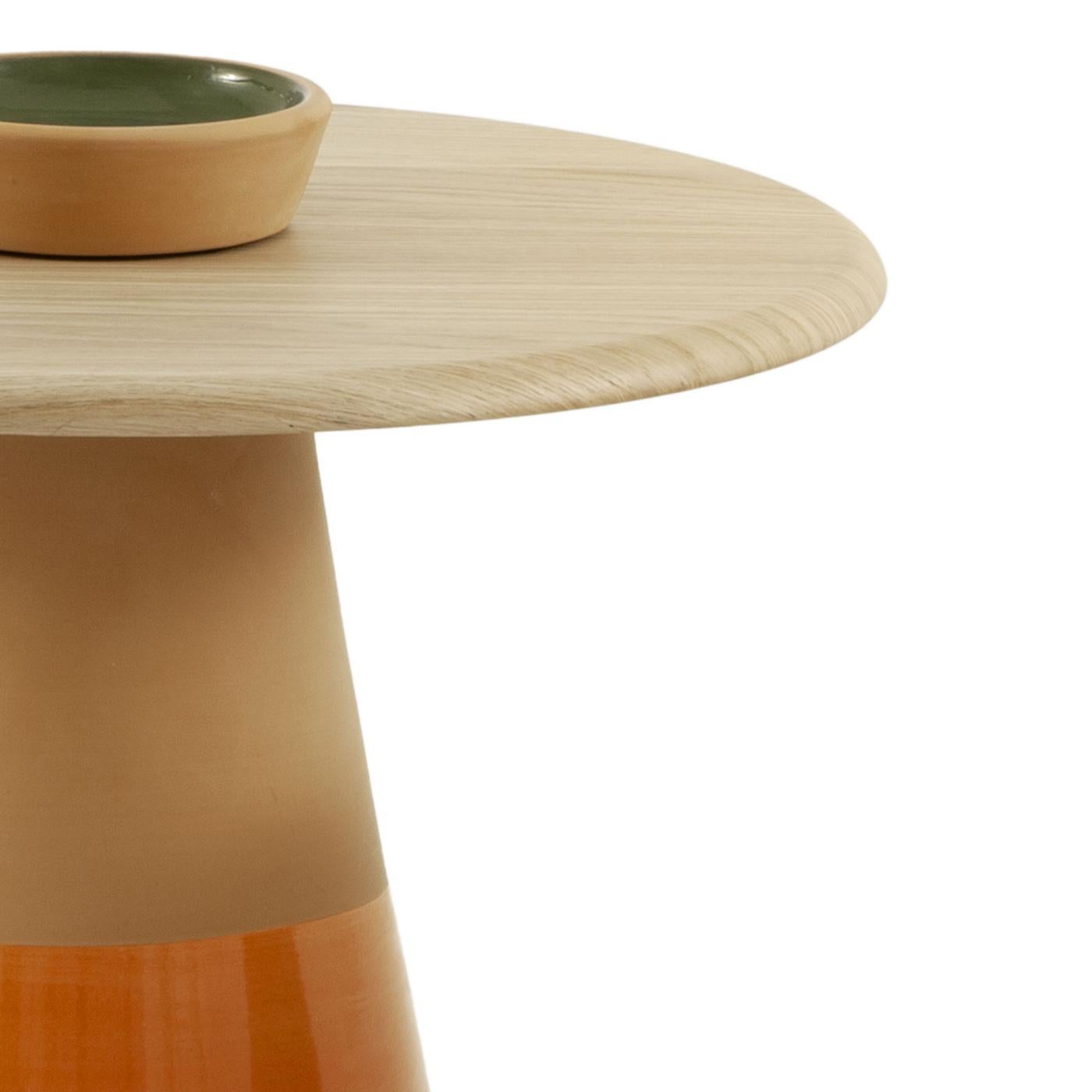 Dieser mit Präzision aus natürlichem Terrakotta-Ton gefertigte Wohnzimmertisch ist mit einer glänzenden mandarin-orangenen Emaille-Einlage versehen. Seine Platte aus MDF-Eichenfurnier, die mit Membranpressung veredelt ist, ergänzt den erdigen