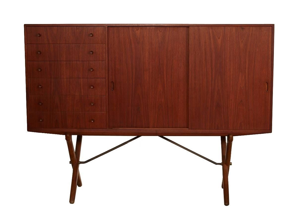 Danish modern teak credenza designed by Hans J. Wegner for Andreas Tuck. Features six dovetail drawers and two sliding doors concealing three adjustable shelves and shallow drawers/trays. This piece is in excellent vintage condition.