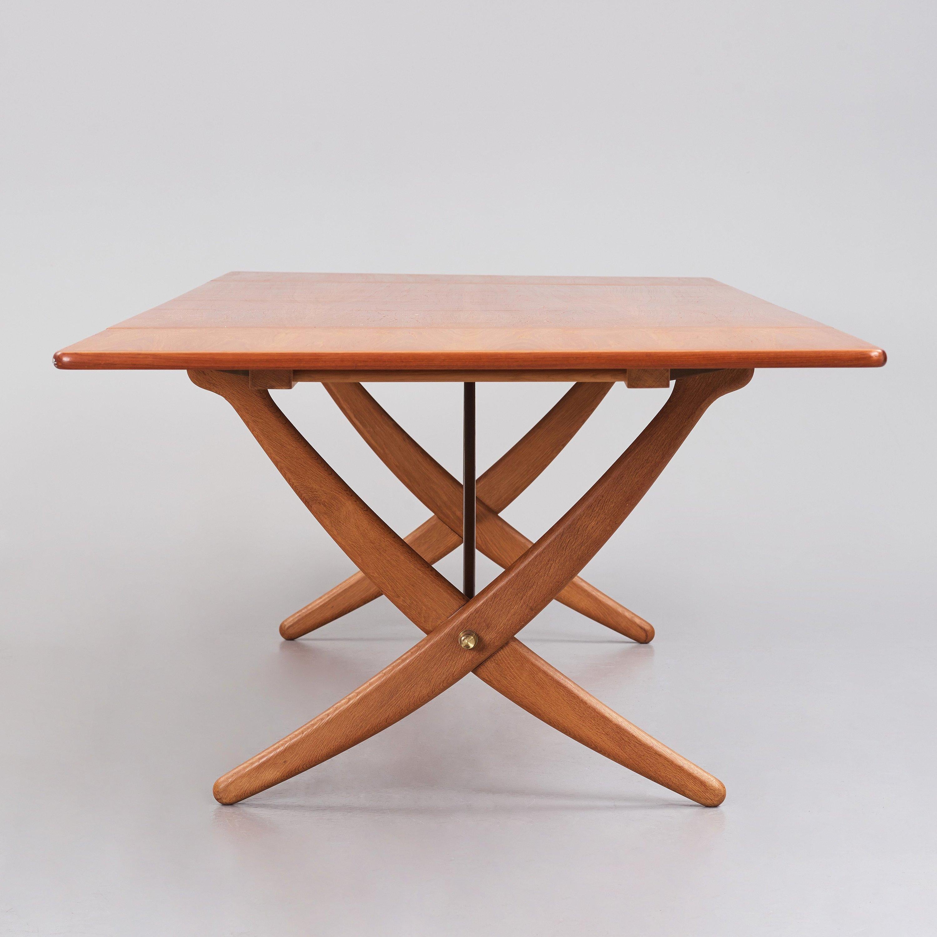 Il s'agit d'une rare et ancienne table de salle à manger Hans J. Wegner AT-314 en chêne à pied sabre, avec deux pieds tombants, des pieds croisés et des châssis en laiton. Conçue par Wegner en 1950 et fabriquée par l'ébéniste Andreas Tuck au