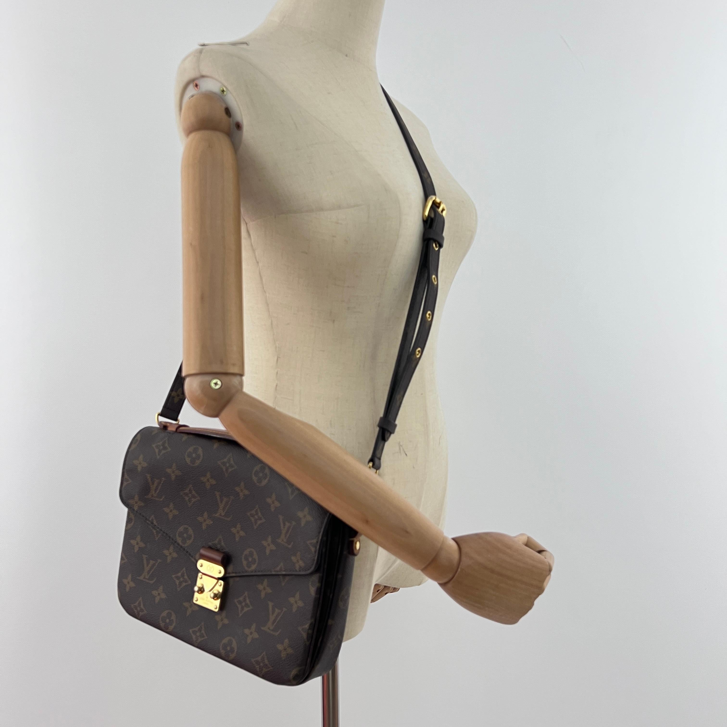 Magnifica borsa a tracolla LOUIS VUITTON modello Metis in pelle e cuoio di colore marrone, caratterizzata da una decorazione dorata.
La borsa è dotata di un fermoir pression.
L'interno si compone di due scompartimenti principali e di una poche