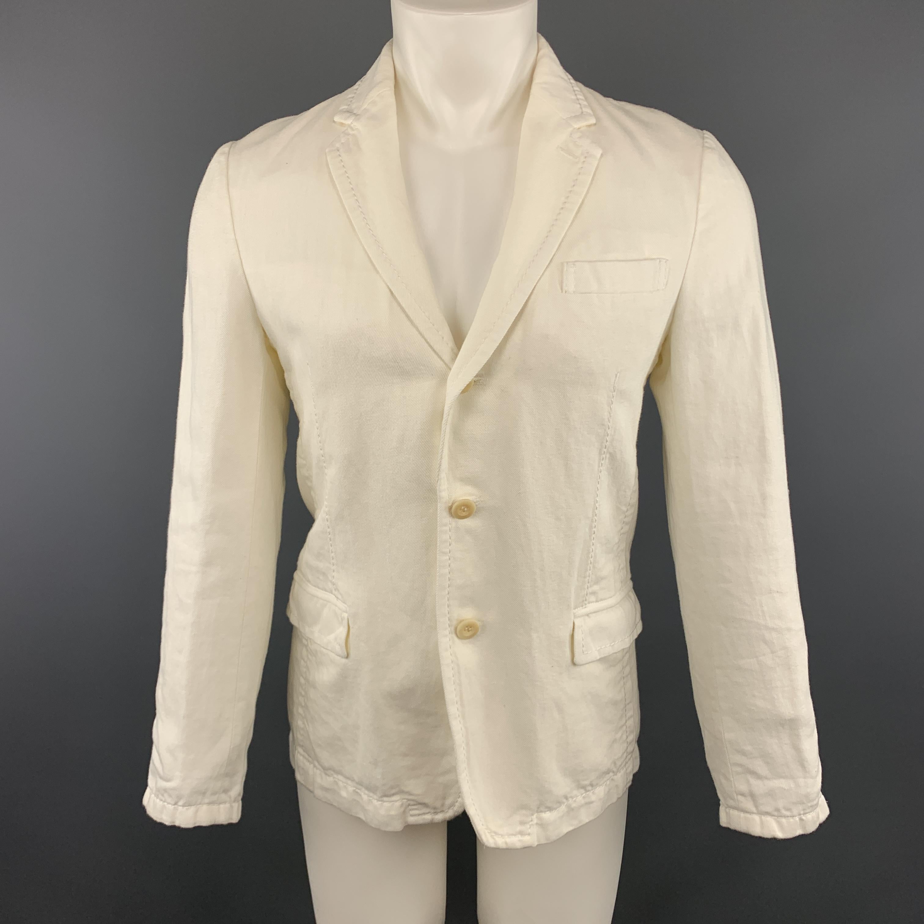 SACAI Sport Coat comes in an off white tone in solid cotton / linen material, with a notch lapel, a ruffle detachable panel, slit and flap pockets, functional buttons at cuffs, a single vent at back, unlined. Made in Japan.

Excellent Pre-Owned