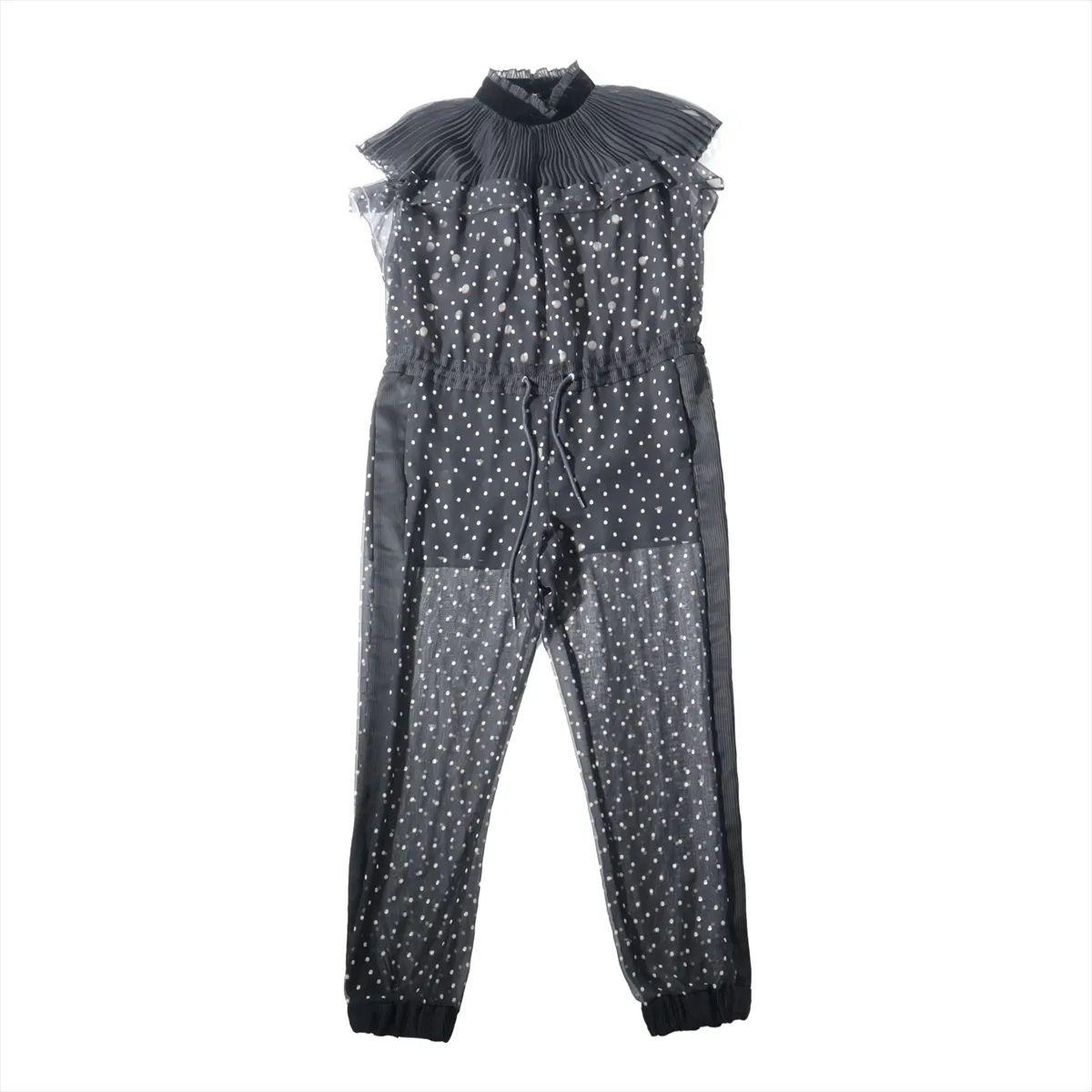 Der Sacai Mock Neck Polka Dot Jumpsuit in Schwarz ist eine auffällige Verschmelzung von Eleganz und Modernität und verkörpert die charakteristische Hybrid-Ästhetik der Marke. Der aus zartem schwarzem Mesh gefertigte Jumpsuit ist mit einem