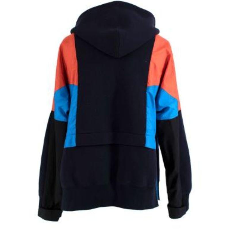 Sacai navy & orange cotton blend zipped hooded jacket

- Made of luscious cotton and nylon.
- Perfect fitting jacket. 
- 2 exterior pockets. 
- Orange and blue at either side. 
- Zip jacket with buttoned bottom. 

Made in Japan.
Do not
