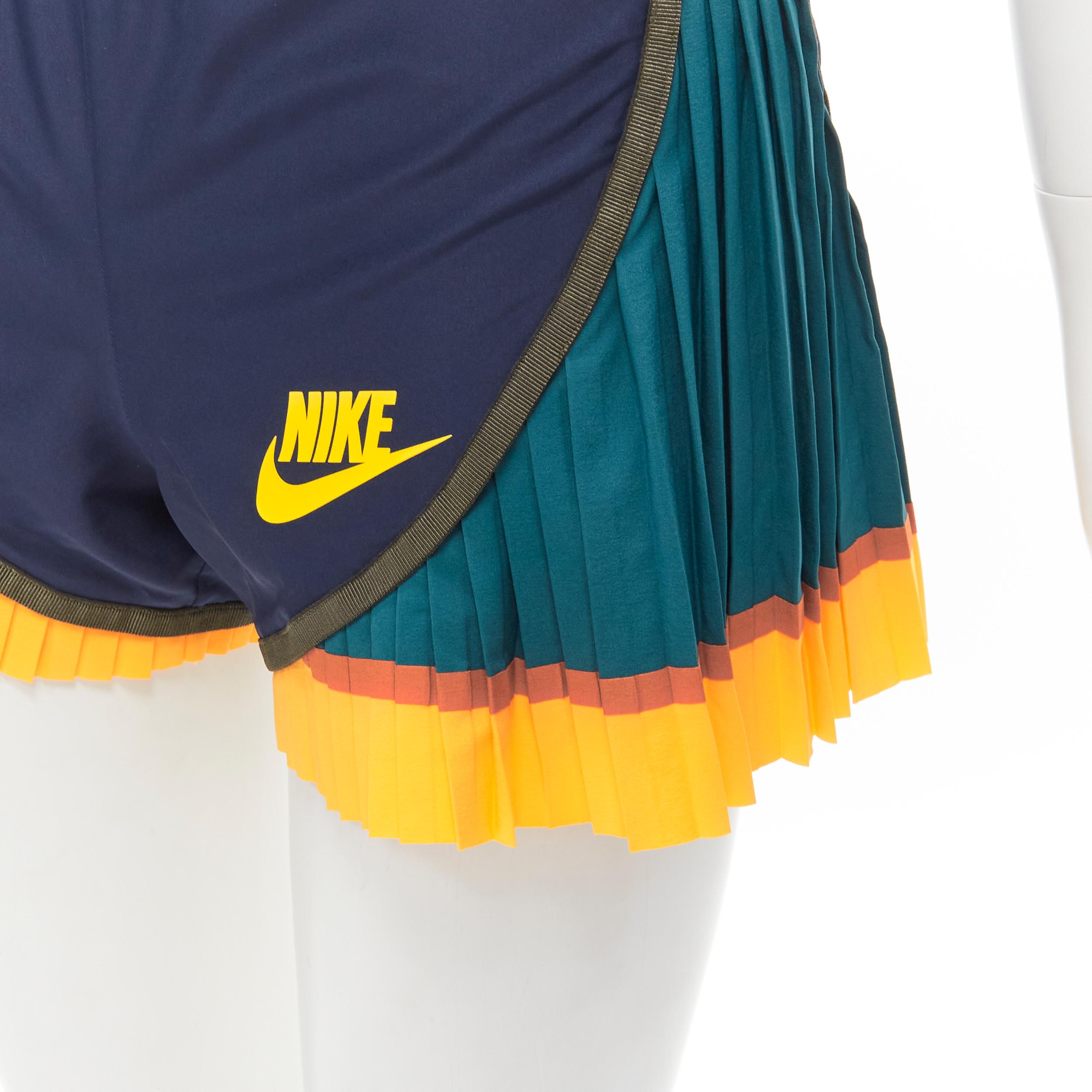 SACAI NIKE navy nylon green yellow pleated hem shorts XS 
Reference: ANWU/A00515 
Brand: Nike 
Designer: Chitose Abe 
Collection: Sacai Collaboration 
Material: Nylon 
Color: Navy 
Pattern: Solid 
Closure: Stretch 
Extra Detail: Drawstring at