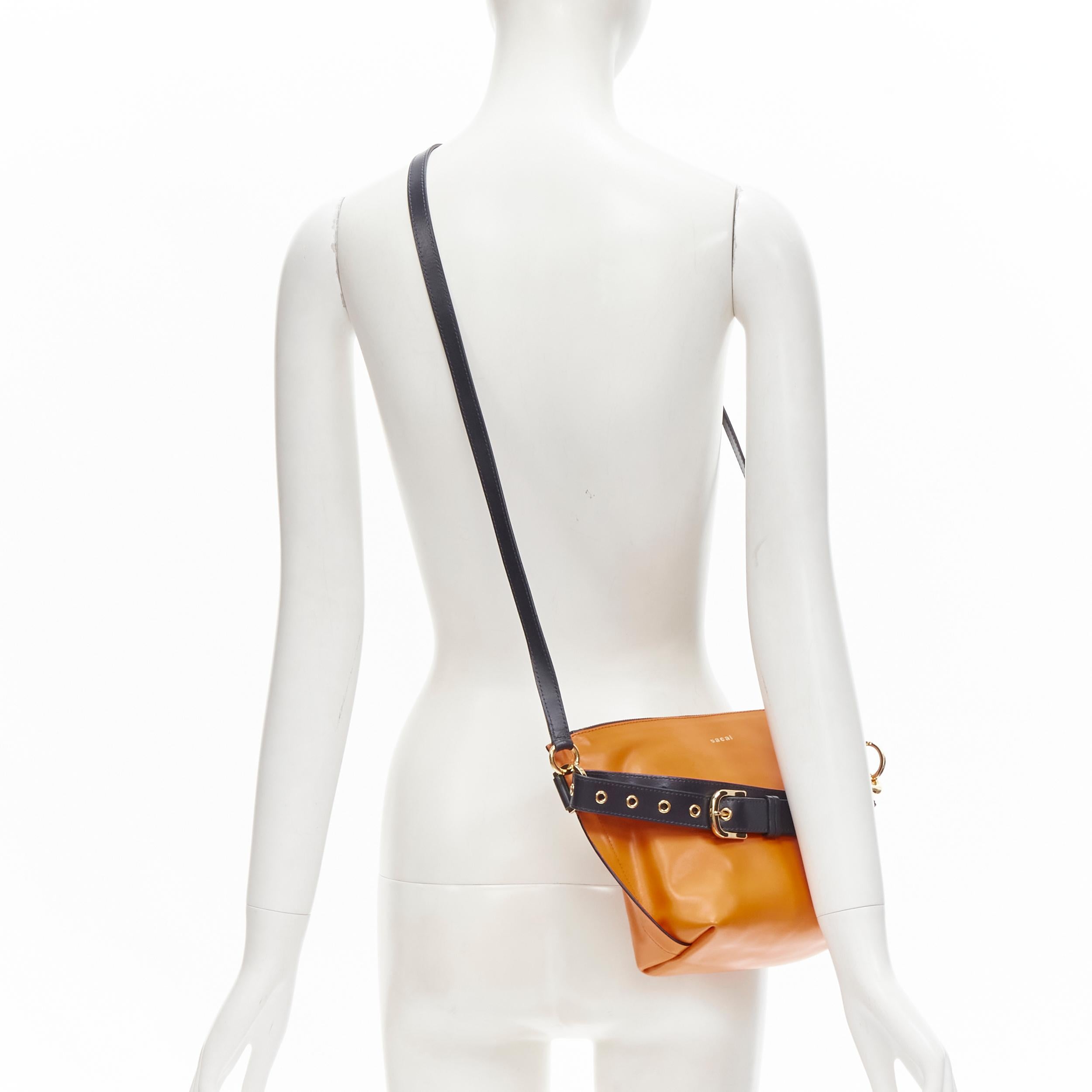 SACAI orange leather navy belt strap gold logo crossbody bag 
Reference: ANWU/A00030 
Brand: Sacai 
Designer: Chitose Abe 
Model: Belt Bag 
Material: Leather 
Color: Orange 
Pattern: Solid 
Closure: Zip 
Extra Detail: Navy leather belt with