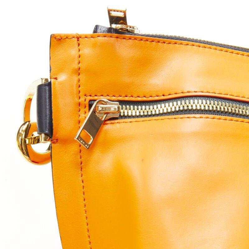 Bolso bandolera SACAI de piel naranja con cinturón azul marino y logotipo dorado en venta 3