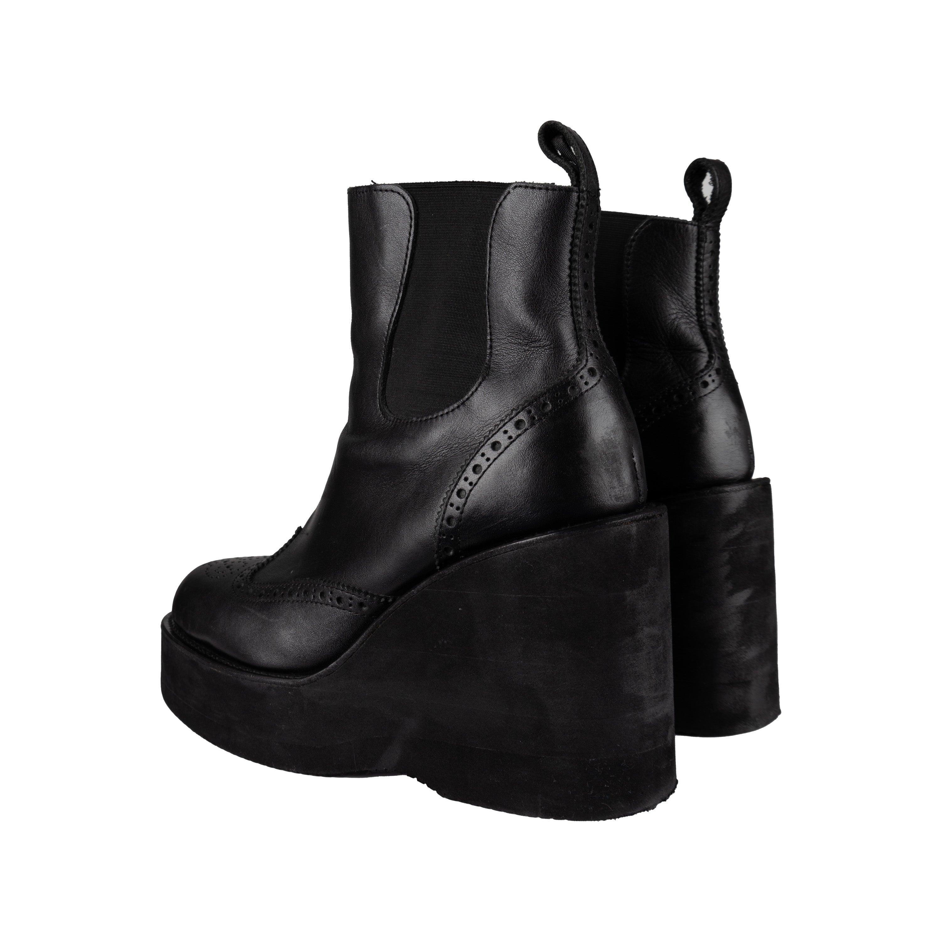 Expertly crafted, the Sacai Platform Ankle Boots offer both style and functionality. These Chelsea styled boots feature a platform heel and perforated design, adding a unique touch to the classic silhouette. Made from black leather and featuring a