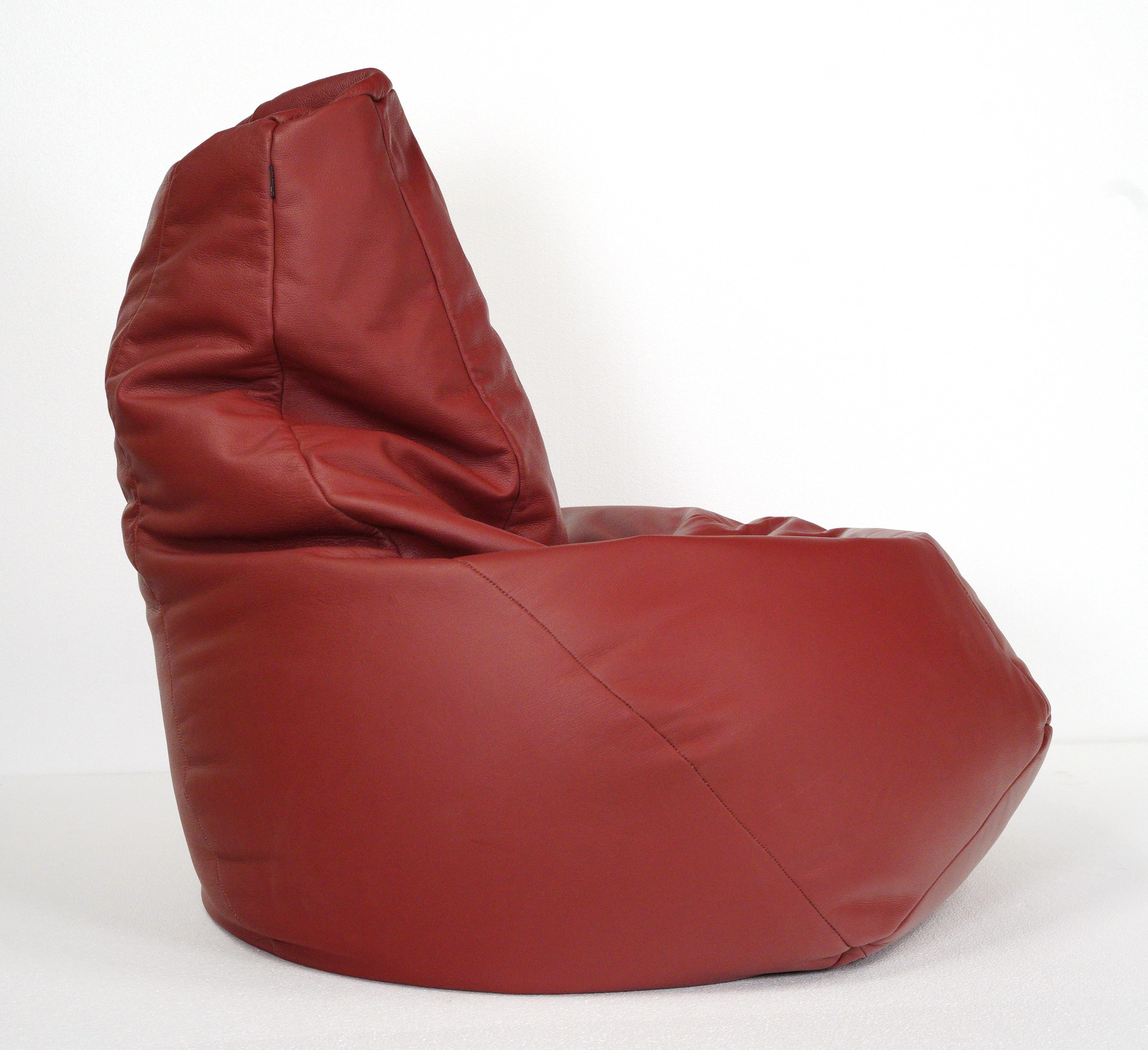 This Sacco bean bag chair is anatomically designed in red leather with polystyrene pellets, making it durable and comfortable. Made by Zanotta and designed by Gatti, Paolini, Teodoro. Good condition with surface wear from prior use with minor stains