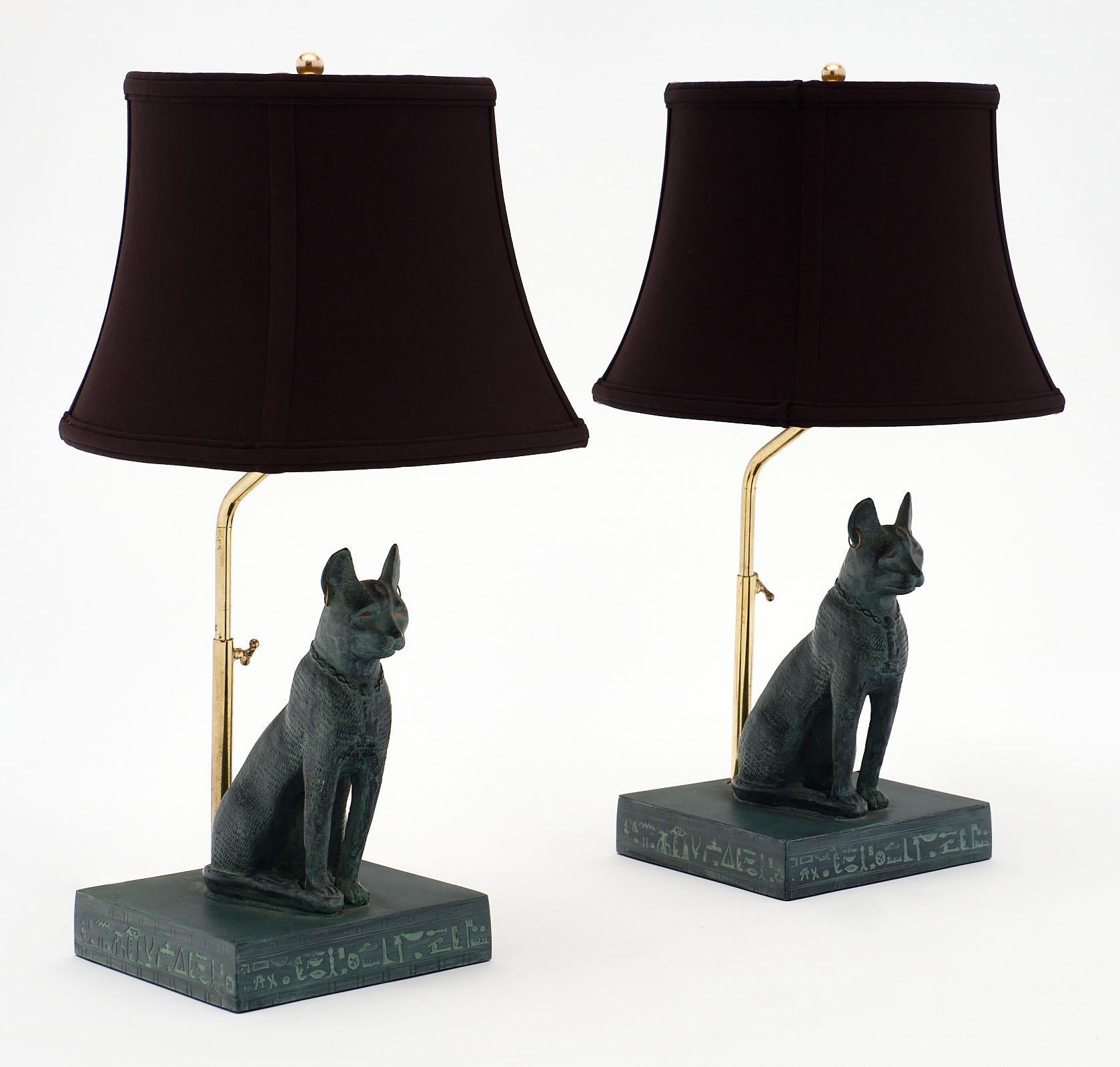A pair of stylized sacred Egyptian cat lamps each sitting on a base adorned with hieroglyphs. This unique pair has been newly wired to fit US standards.