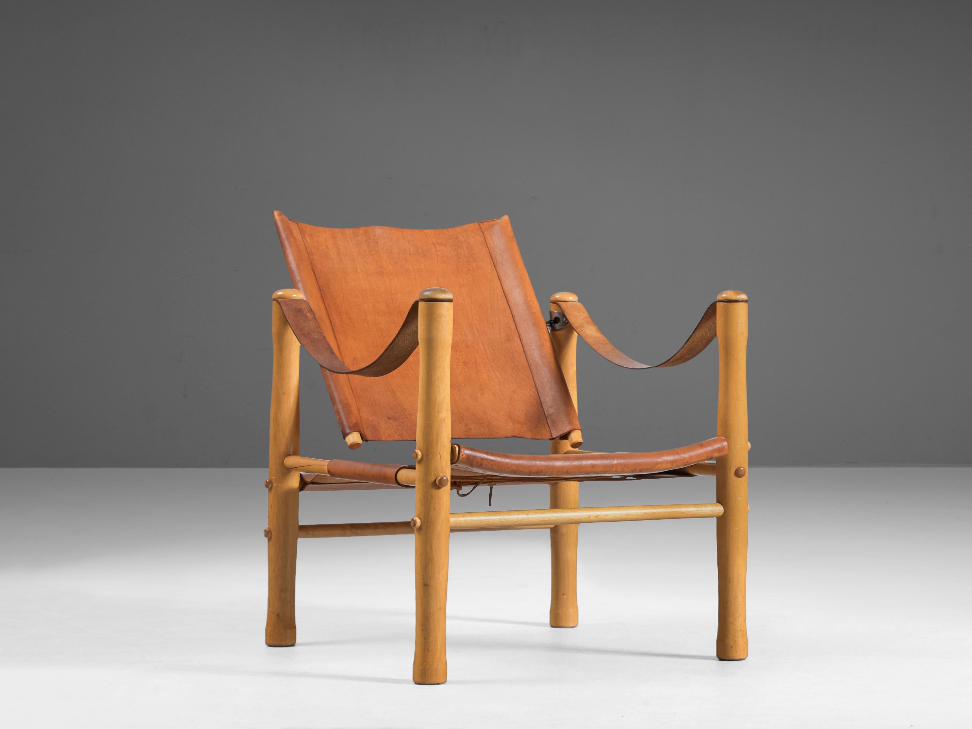 Nordiska Kompaniet, armchair, leather, birch, Sweden, 1950s

This elegant safari lounge chair is crafted from natural cognac brown leather, which has developed a beautiful patina over time, adding to the chair's character. The well-designed lines of