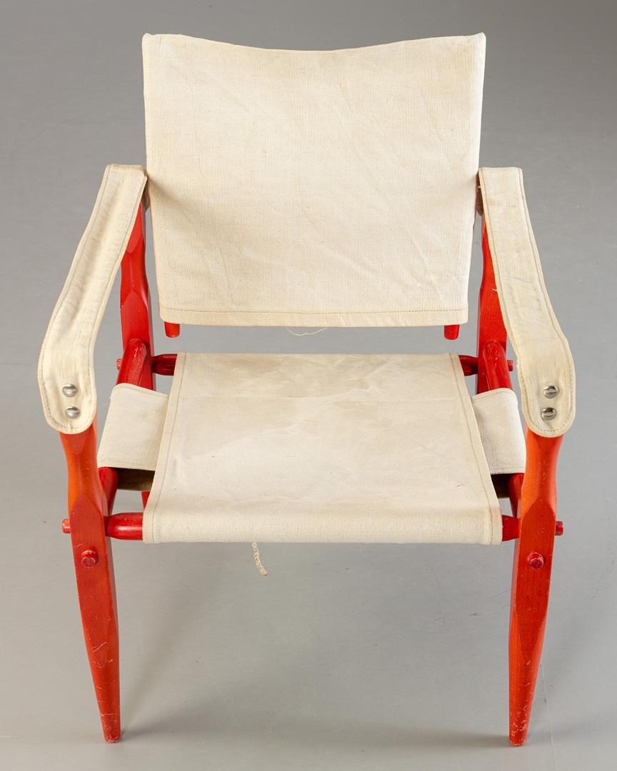 The 1960s safari chair, with its unmistakable cotton and red-painted wood design, is an icon of retro style that encapsulates the vibrant aesthetics of that decade. This seat, which fuses the comfort of cotton with the warmth and dynamism of red,