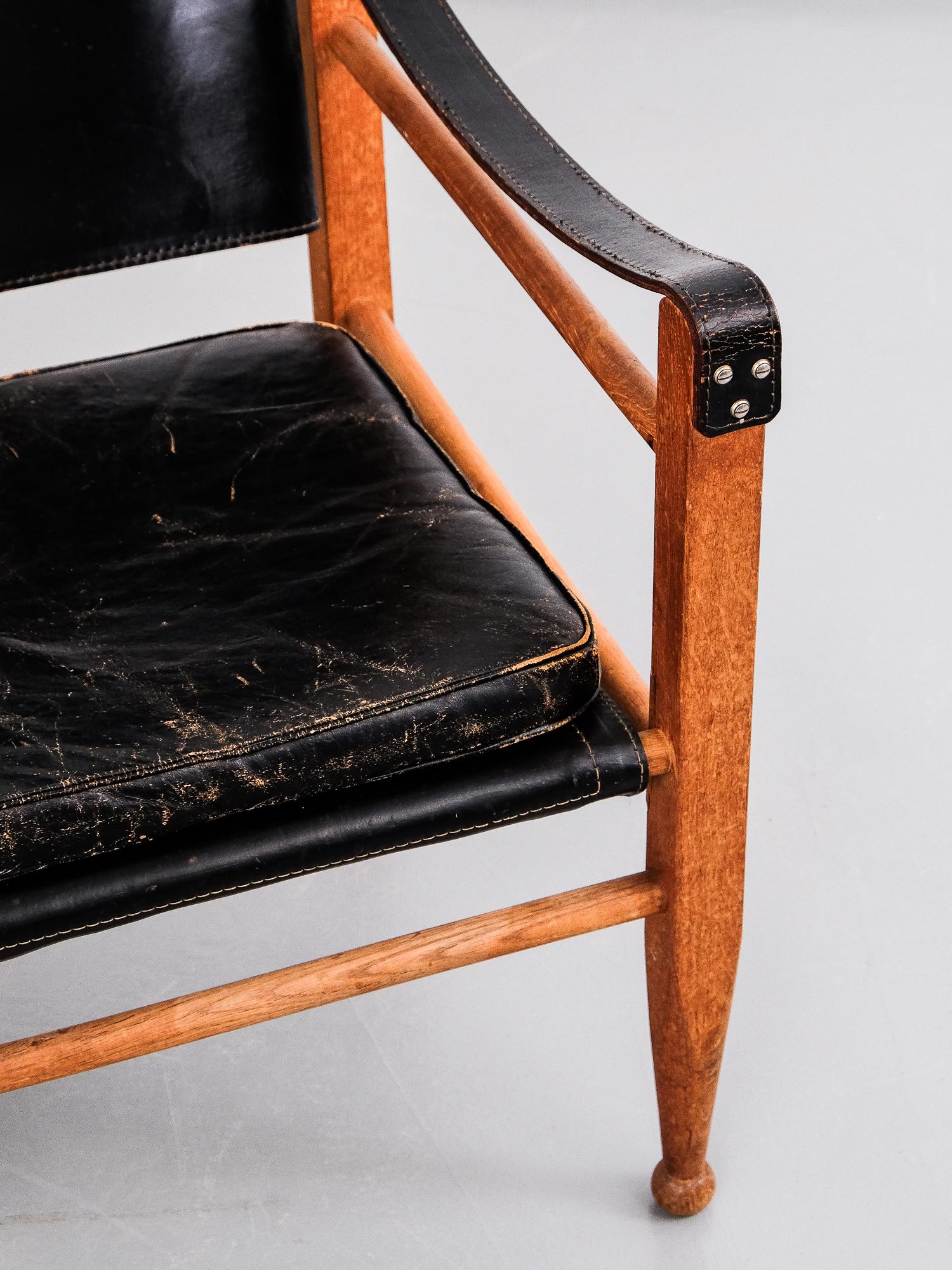 Midcentury Aage Bruun & Søn Safari chair in patinated black leather and solid oak. Excellent patina, Denmark, 1960s.