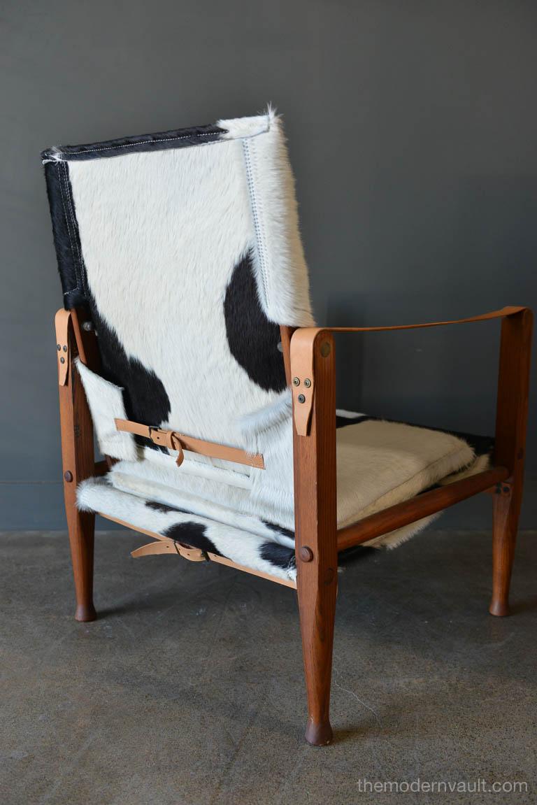 Safari chair by Kaare Klint for Rud Rasmussen circa 1950. Originally designed in 1933. Professionally restored and recovered in beautiful black and white cowhide. The exposed oak frame uses the support of doweled rods, slung leather, and brass