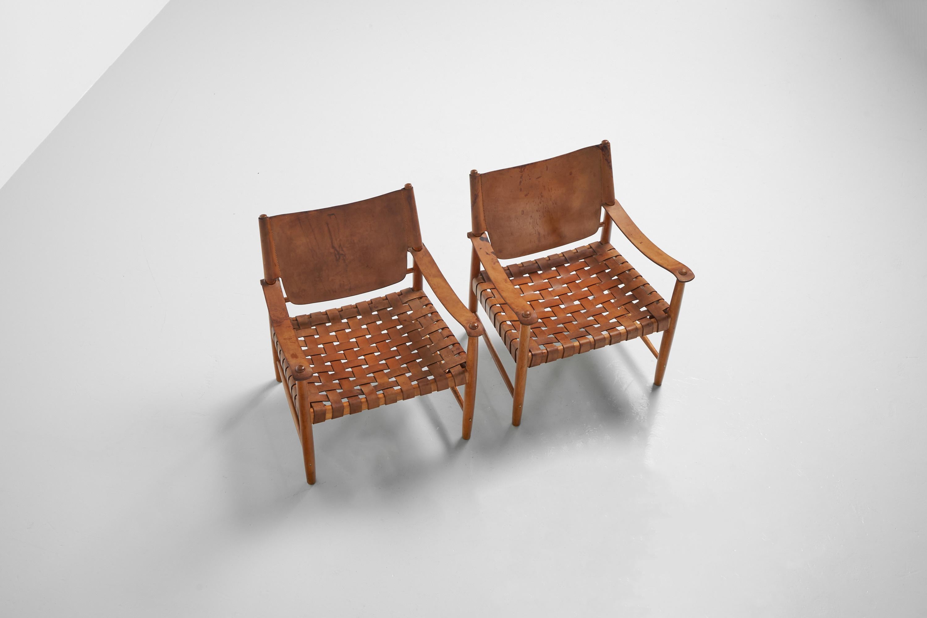 Striking pair of so called 'Safari' arm chairs made by unknown designer or manufacturer in Sweden, 1950s. The chairs have a solid oak wooden frame and the seats are made of beautiful patinated natural leather. The chairs are fully original and in