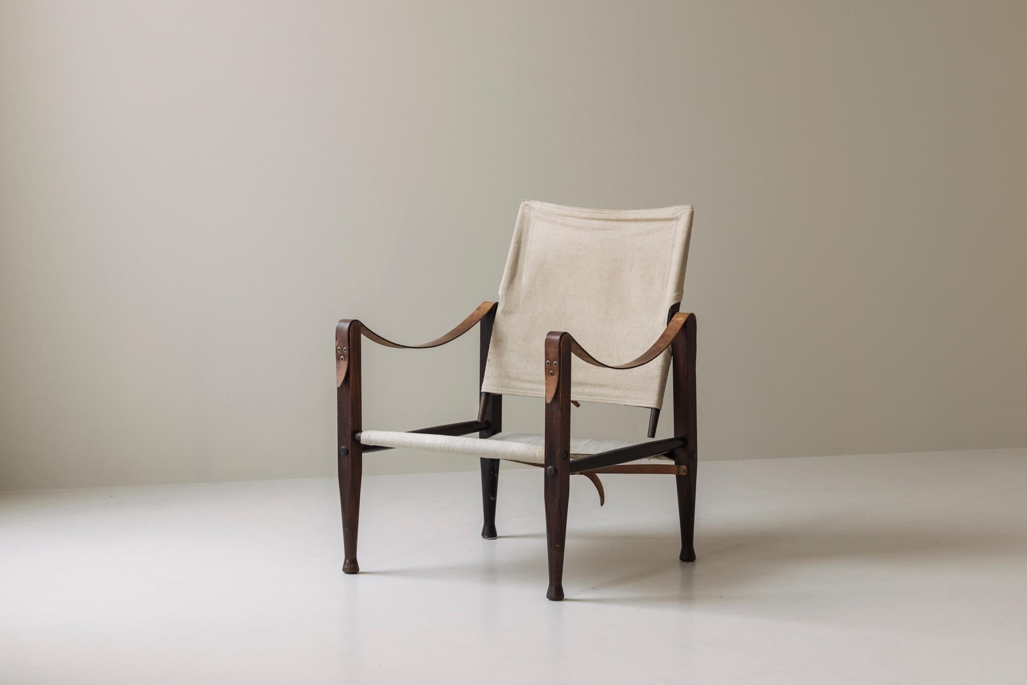Magnifique fauteuil 'Safari' de Kaare Klint pour Rud Rasmussen, Danemark, années 1950. Cette chaise incarne l'essence du modernisme danois, alliant élégance, fonctionnalité et savoir-faire. La structure est en chêne teinté et l'assise et le dossier