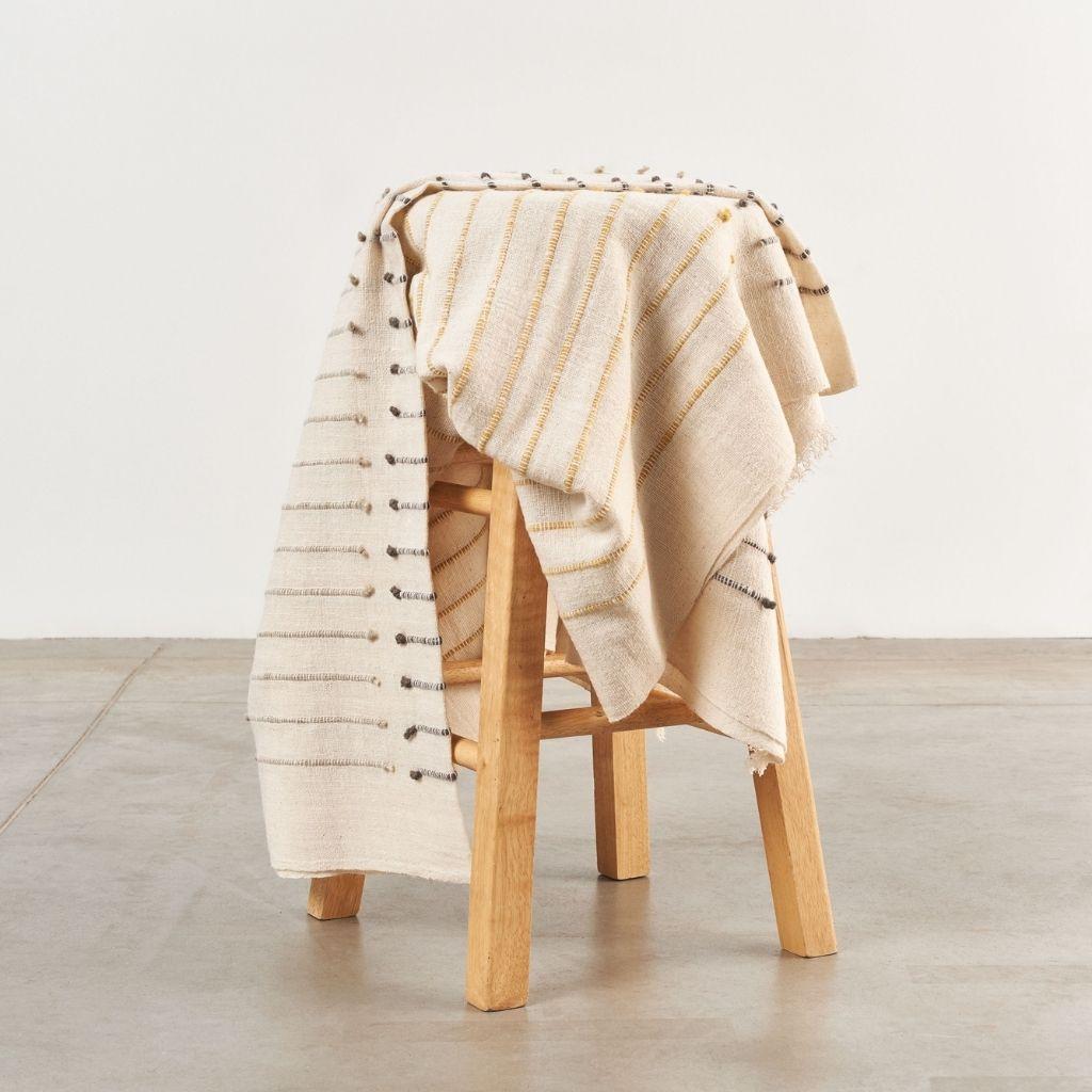 Custom design by Studio Variously, Safari Throw is handwoven by master weavers in Nepal and dyed entirely with earth friendly dyes in soft 100% merino yarn that is hand spun. The design of Chalk Throw is made up of subtle textured stripes that