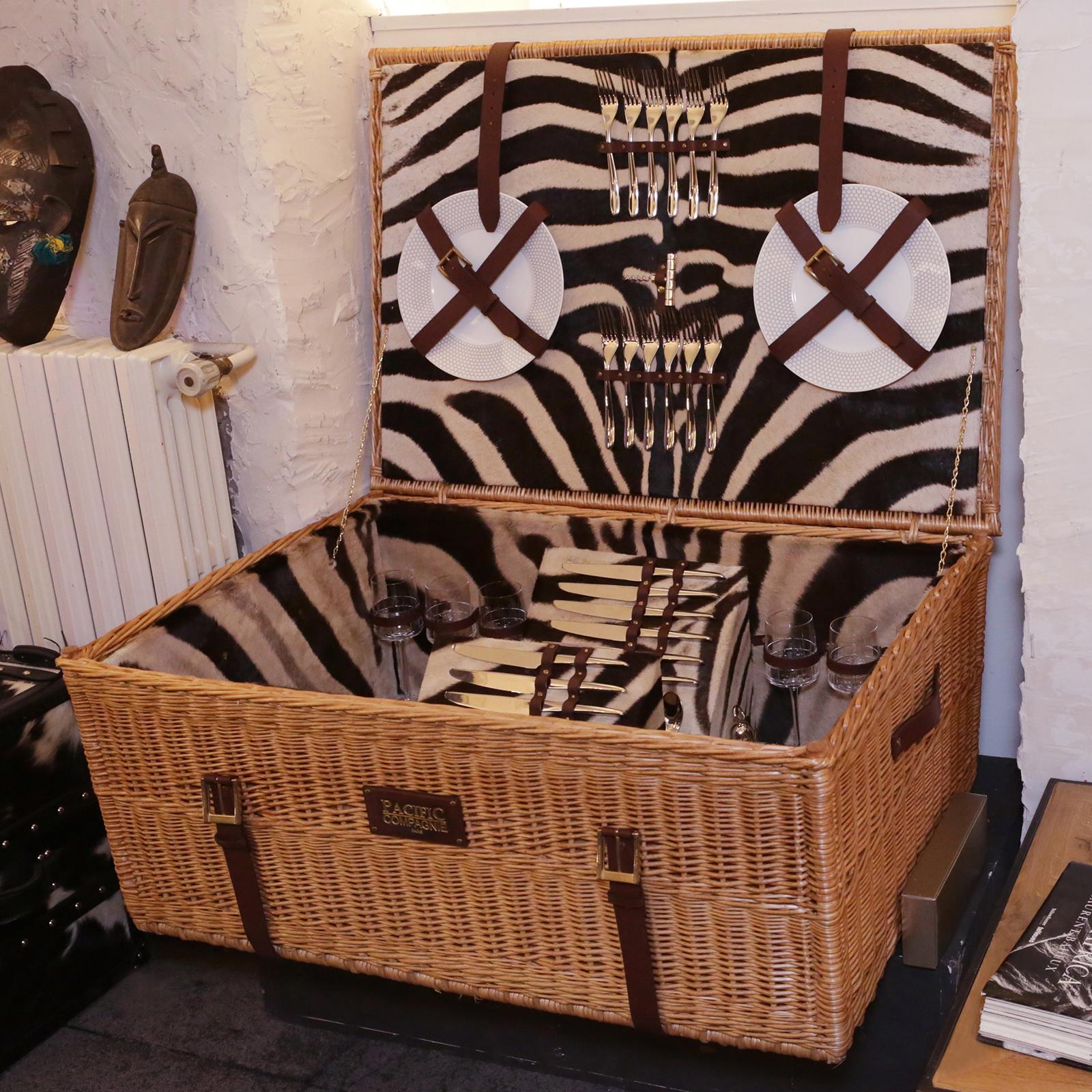 Trunk Safari picnic hand-made in natural wicker and with
inside covered with real Burchell zebra skin. With brown
genuine leather straps. Trunk include a bottle opener, and
salt and pepper pourers, 12 spoons, 12 plates, 12 glasses,
12 forks and