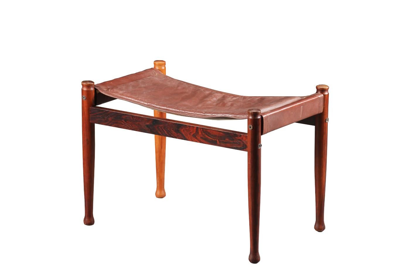 Safari Ottoman designed by Erik Worts for Niels Eilersen, Denmark, 1960. Made of solid rosewood and leather. Very nice patinated leather seat but still in good vintage condition. 

Stamped below

The ottoman is in good condition. The wood was