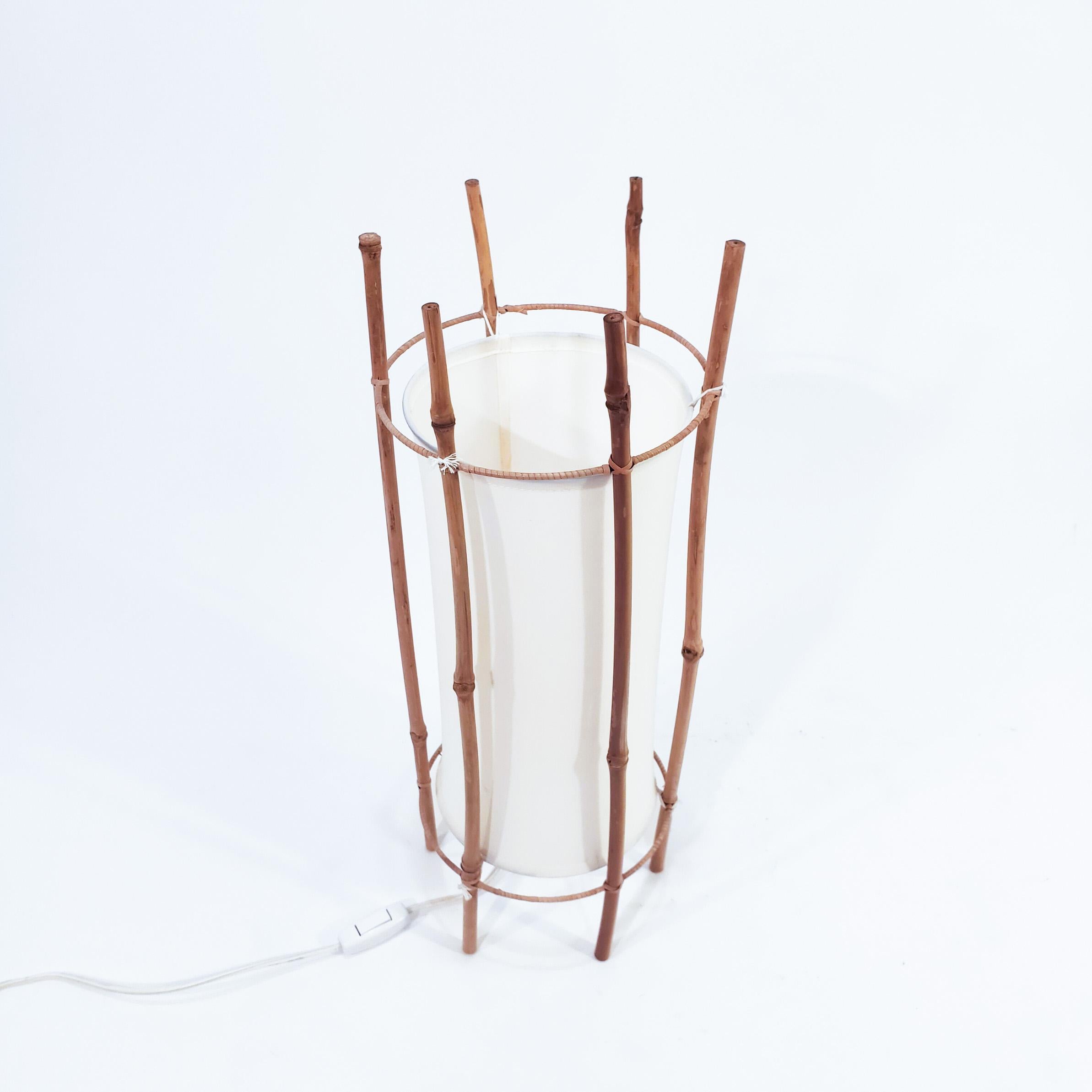 Safari style table lamp designed by the French architect Louis Sognot and made in Italy in the 60s. The structure is made of cane and rattan, and the shade is made of cotton fabric in a light cream colour. Sognot dedicated himself to the design of