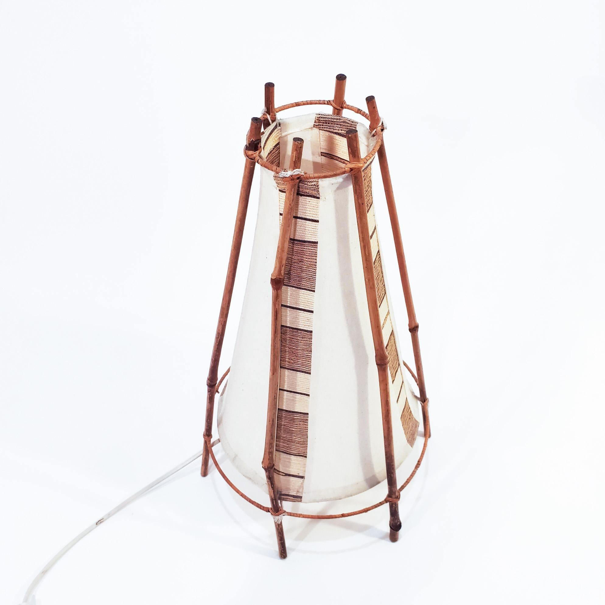 Floor or table lamp designed by the French architect Louis Sognot and manufactured in Italy in the 60s. The structure is made of bamboo and rattan, and the shade is made of cotton with several stripes in earth colors. Sognot dedicated himself to the