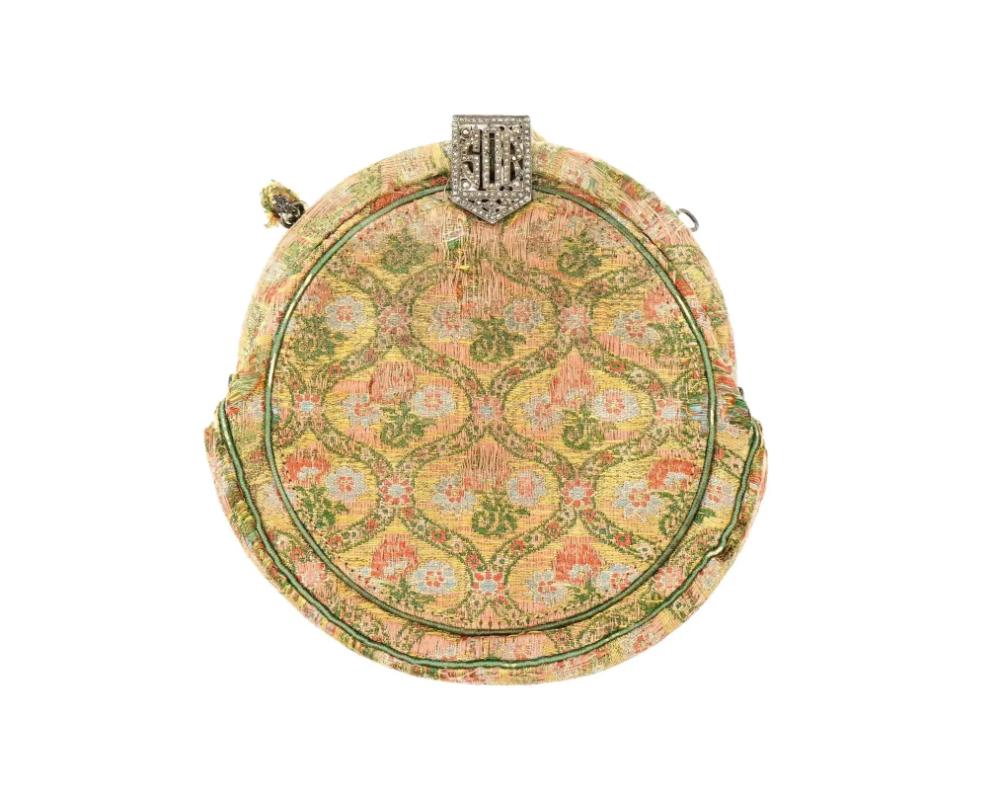 An antique Persian Iranian Safavid hand woven textile hand bag of rounded shape. The textile is decorated with floral motifs. The closure is ornate and made of silver. The bag has is a pocket inside. Antique Iranian Persian Textiles, Embroidered