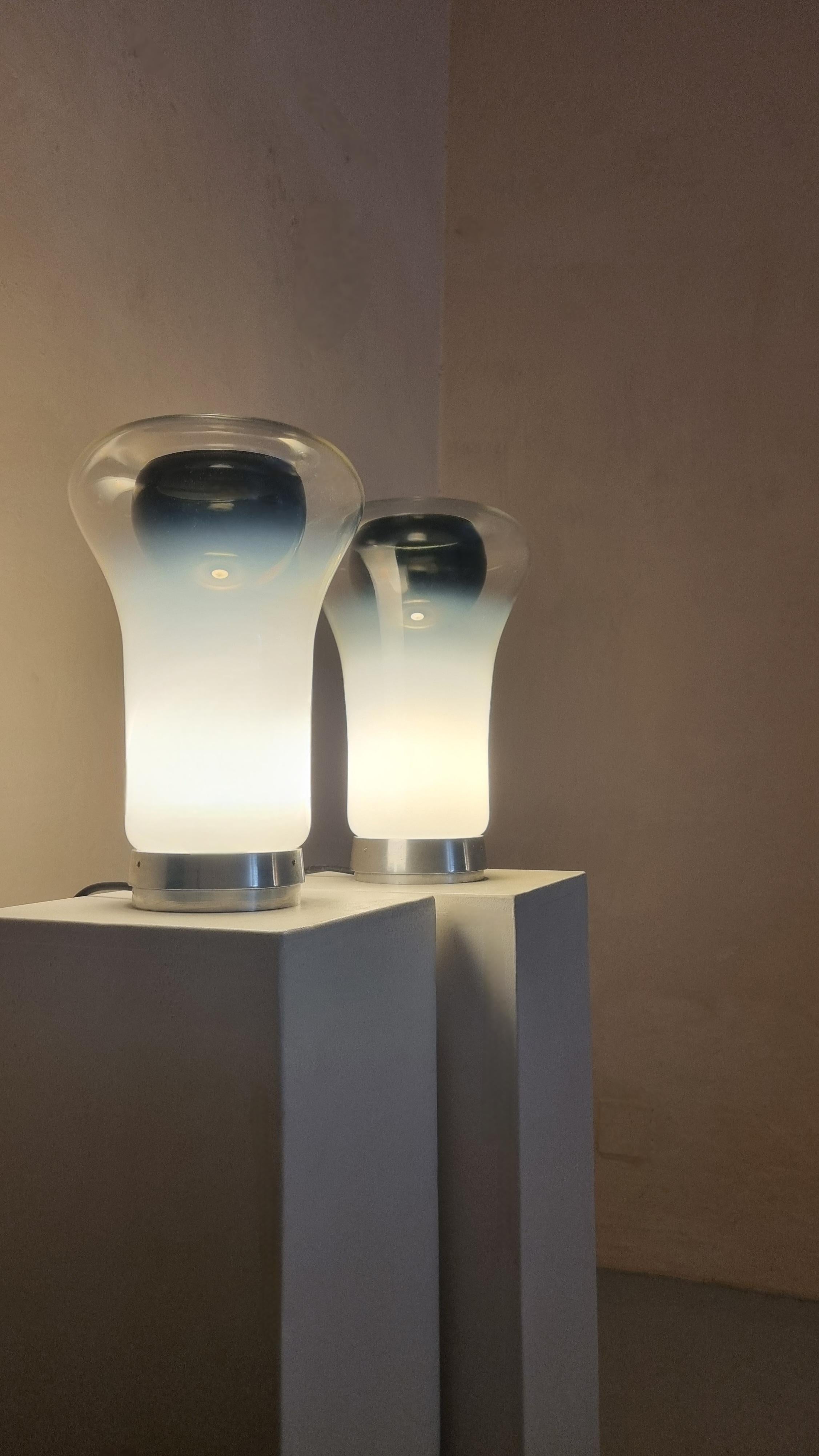 Ensemble de lampes pour tavolo mod. Saffo disegnate da Angelo Mangiarotti, per Artemide, 1967.
Diffuseur en vetro soffiato di Murano, diffuseur interne en vetro fumè, base en alluminio stampato, marchio della manifattura
Disponible sur demande pour