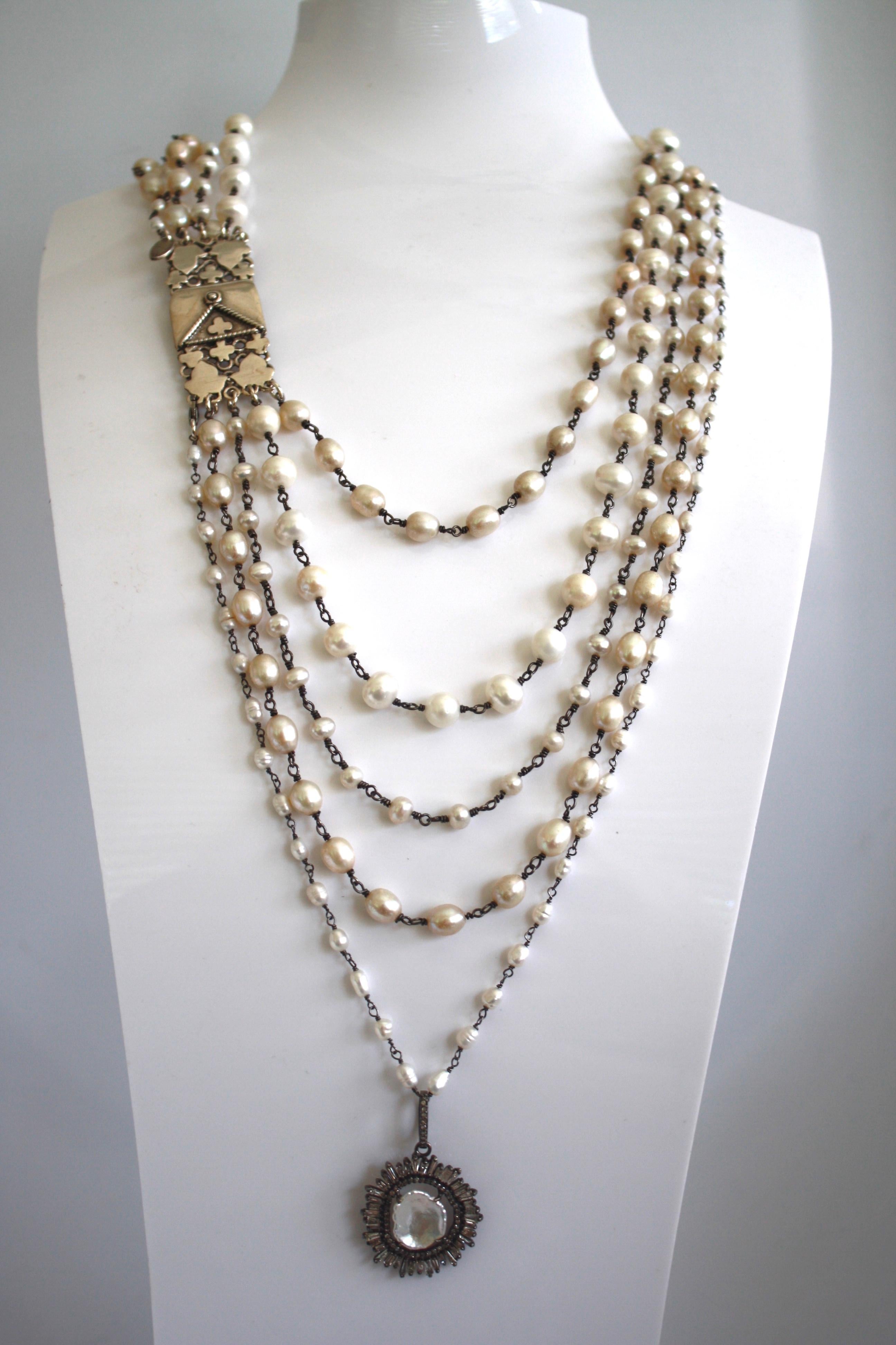 Strands of fresh water pearls are finished with a pendant made of sliced diamonds and baroque pearl. 