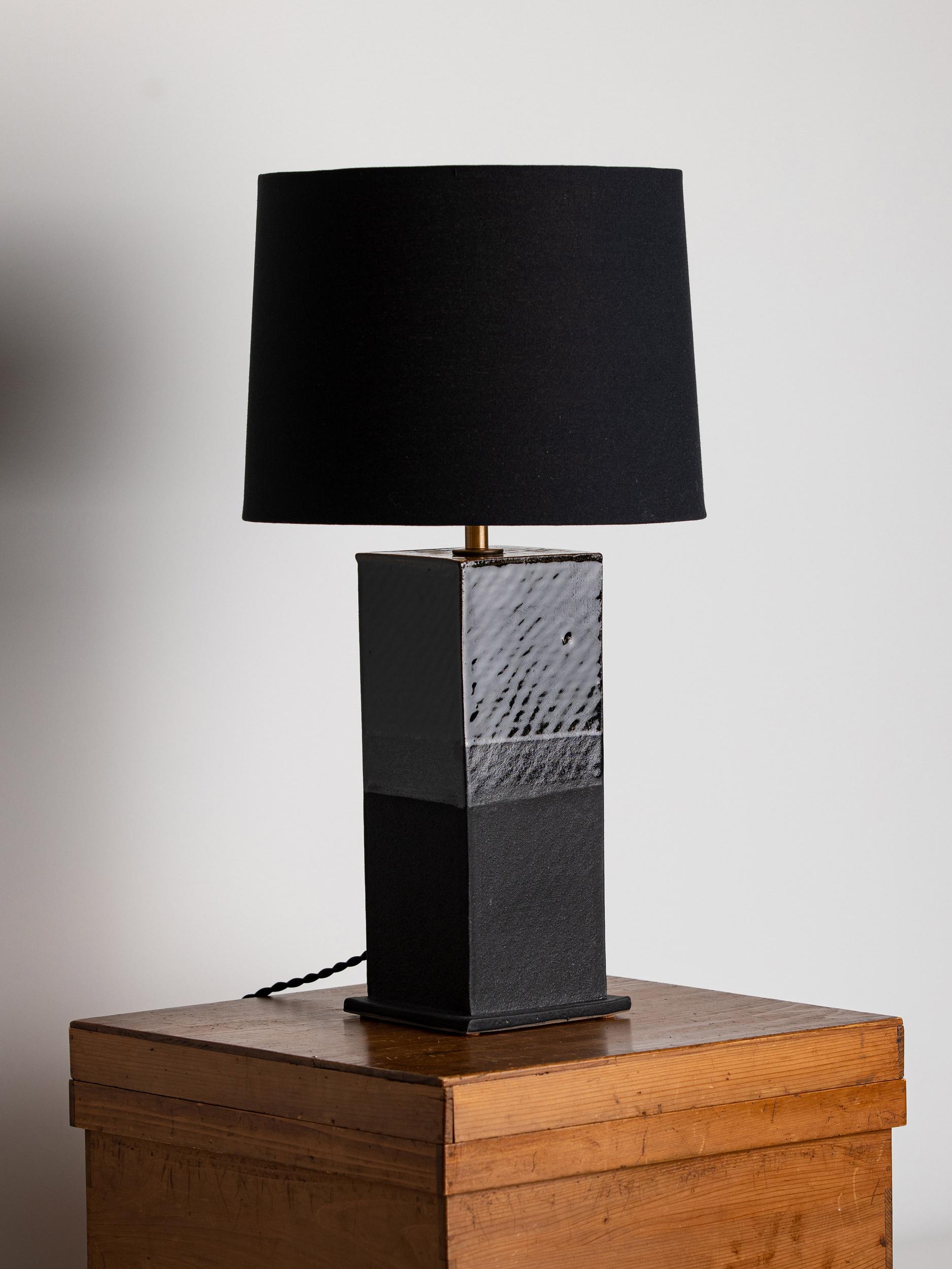 Our stoneware Sag Harbor lamp is handcrafted using slab-construction techniques.

Finish

- Dipped glaze, two colors, pictured in matte-black & bottle-green 
- Antique brass fittings
- Twisted black-cloth cord
- Full-range dimmer socket
-