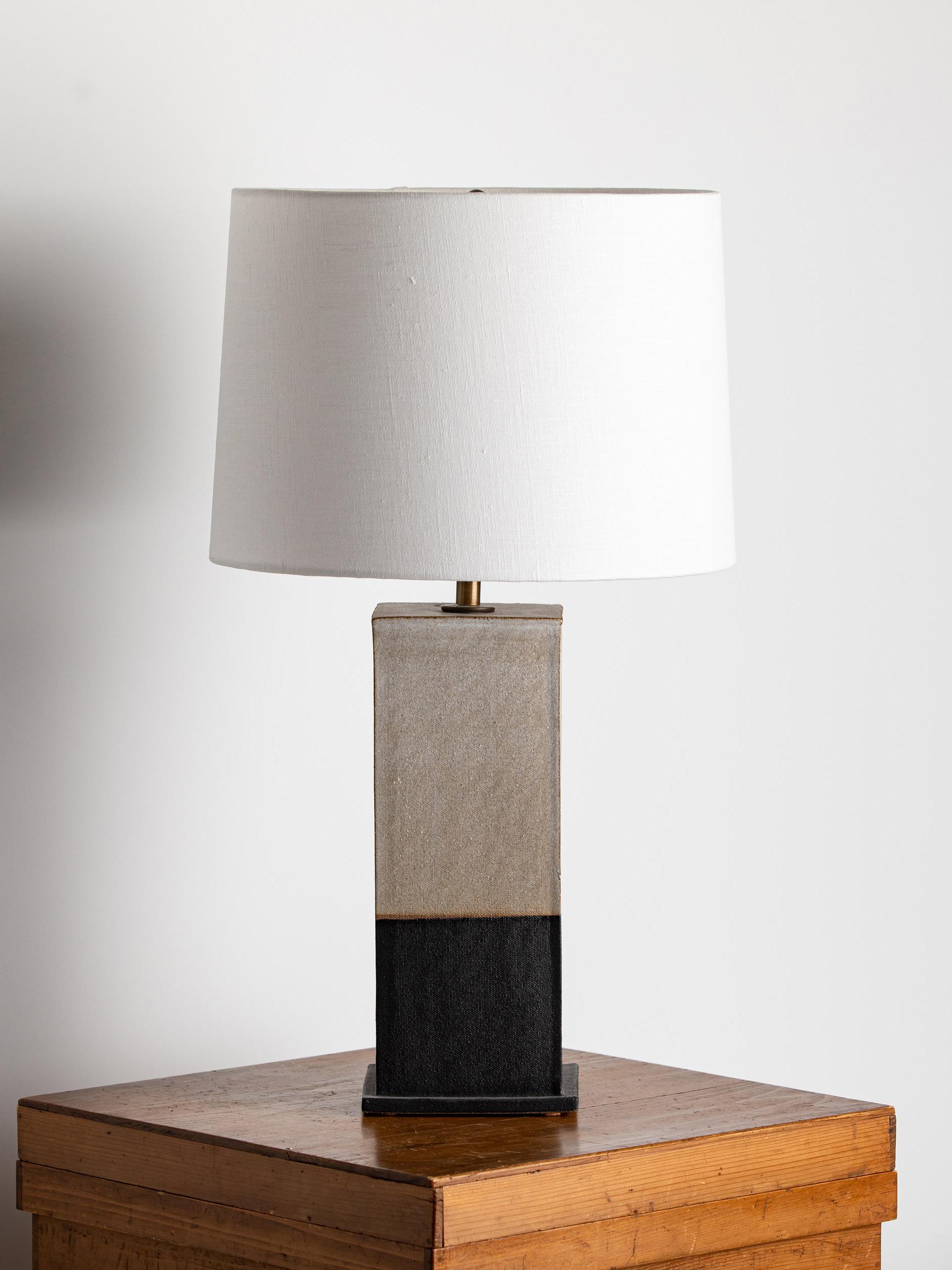 Our stoneware Sag Harbor Lamp is handcrafted using slab-construction techniques.

FINISH

- Parchment and matte-black dipped glaze
- Antique brass fittings
- Twisted black-cloth cord
- Full-range dimmer socket
- Black-linen or off-white paper
