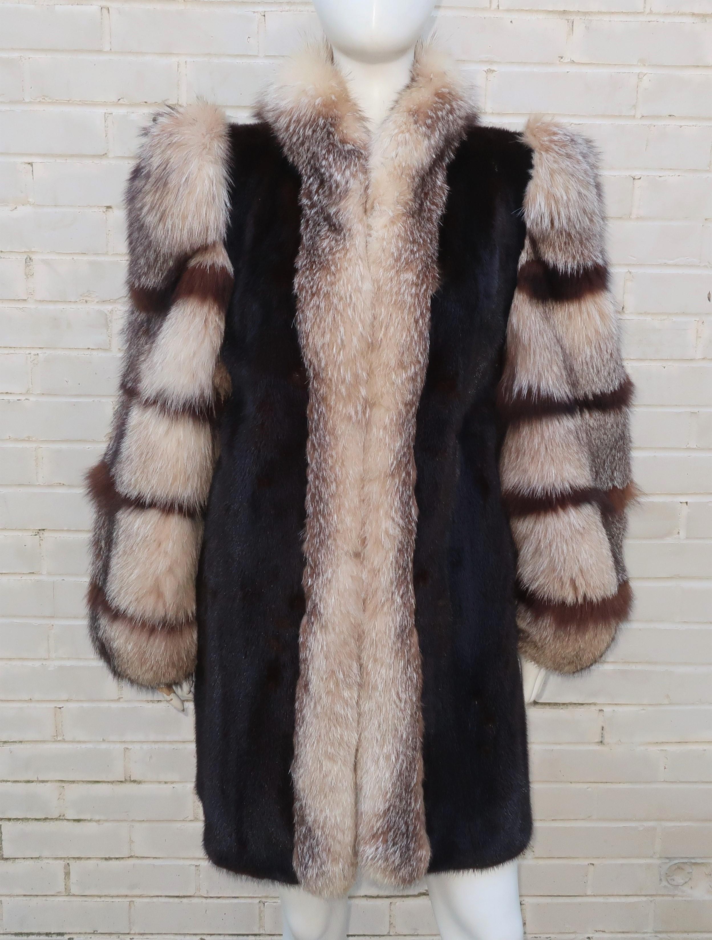 Wrap yourself in luxury with a dramatic 1980's style.  This fur stroller length coat is designed with lush Saga brand dark brown mink accented with fox fur trim and puff sleeves.  The coat hooks down the front with hidden pockets and elasticized