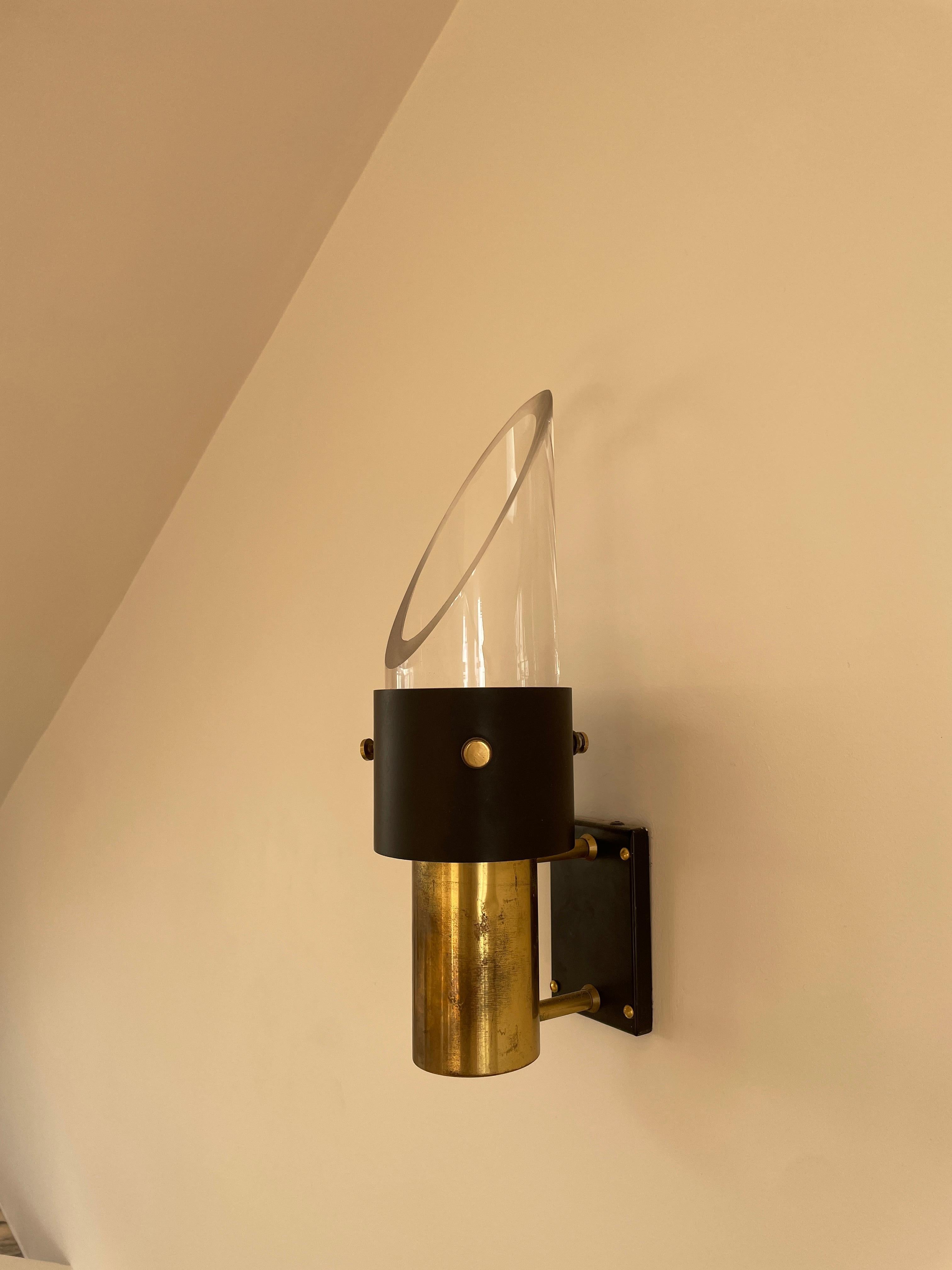 These beautiful wall lights provide slight directional lighting due to the slanted glass shade attached. Beautiful patina evident on the solid brass hardware. An incredibly striking lighting solution.
