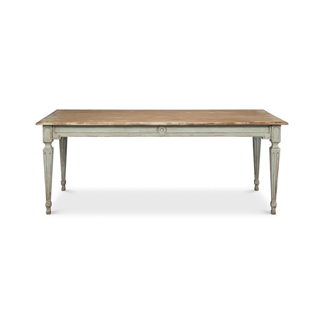 La table dégage un charme raffiné avec ses lignes classiques et sa finition vieillie bien aimée. Le plateau en bois naturel est patiné par les intempéries, alliant harmonieusement chaleur rustique et savoir-faire sophistiqué. Une base peinte à la